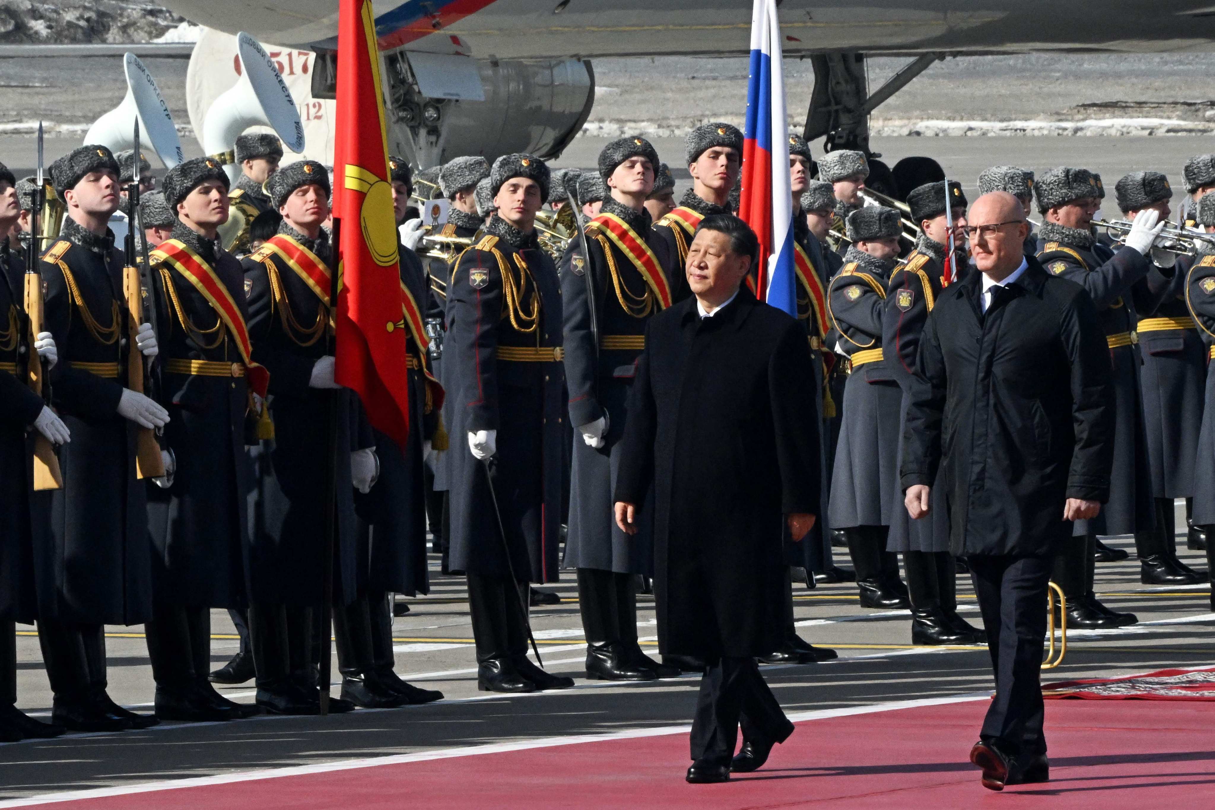 Chinese President Xi Jinping, accompanied by Russian Deputy Prime Minister Dmitry Chernyshenko, walks past honour guards at Moscow’s Vnukovo airport on March 20. Photo: Kommersant / AFP