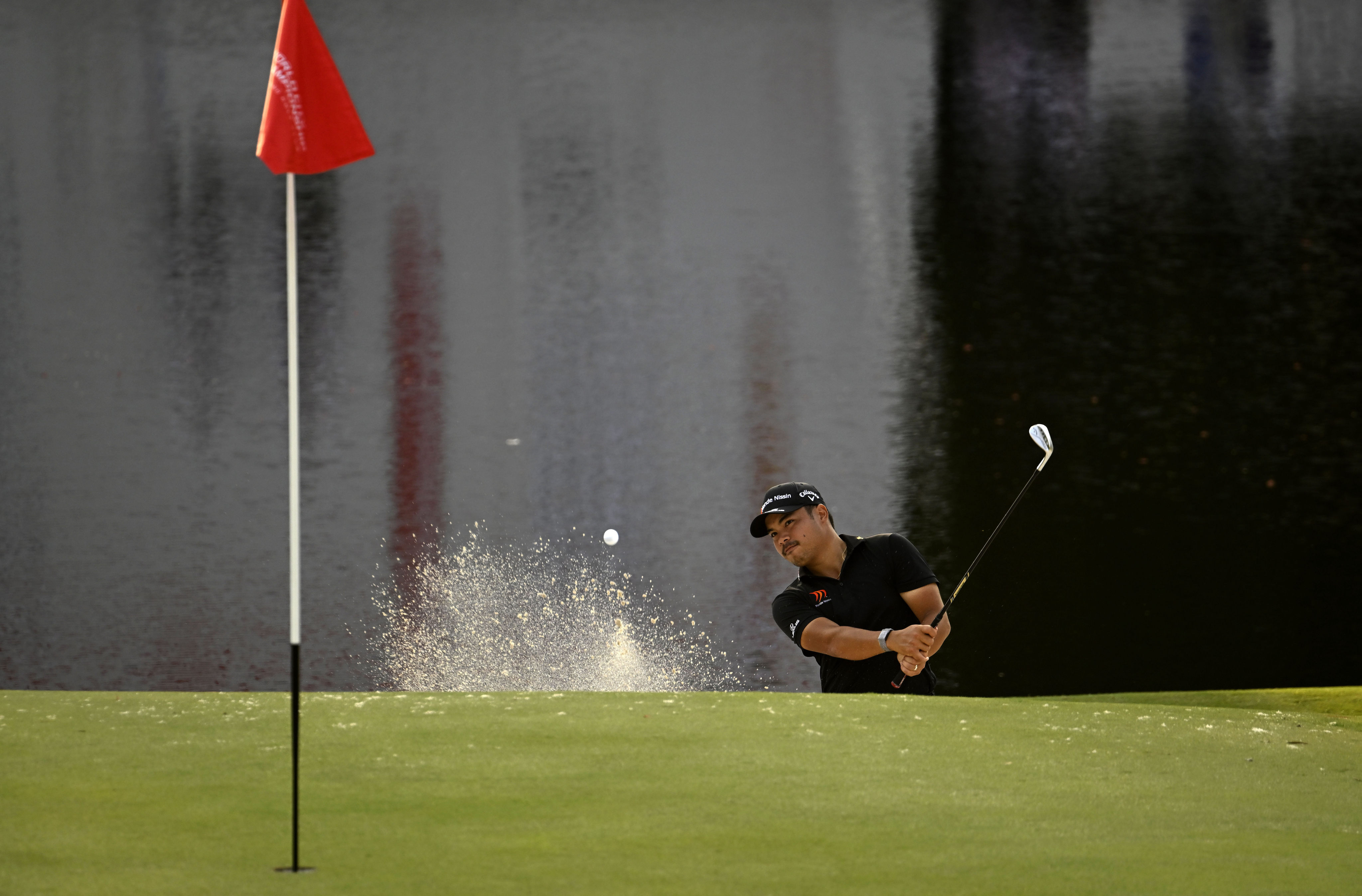 Miguel Tabeuna chips out of the greenside bunker on 18 during the first round of the World City Championship at Hong Kong Golf Club. Photo: Asian Tour.