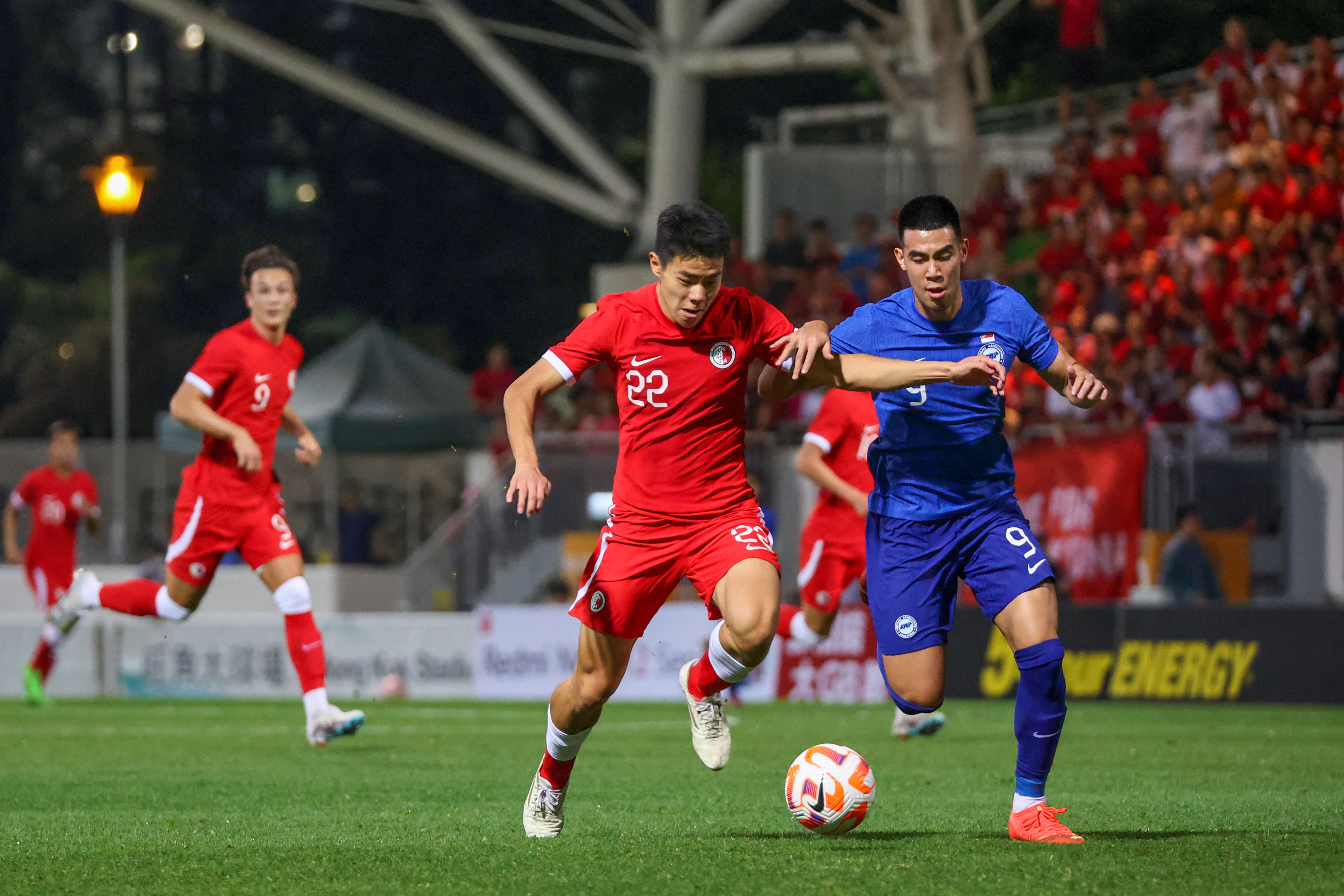 Sun Ming-Him of Hong Kong (in red) vies with Lionel Tan Han Wei, who scored at both ends in the international friendly. Photo: Edmond So