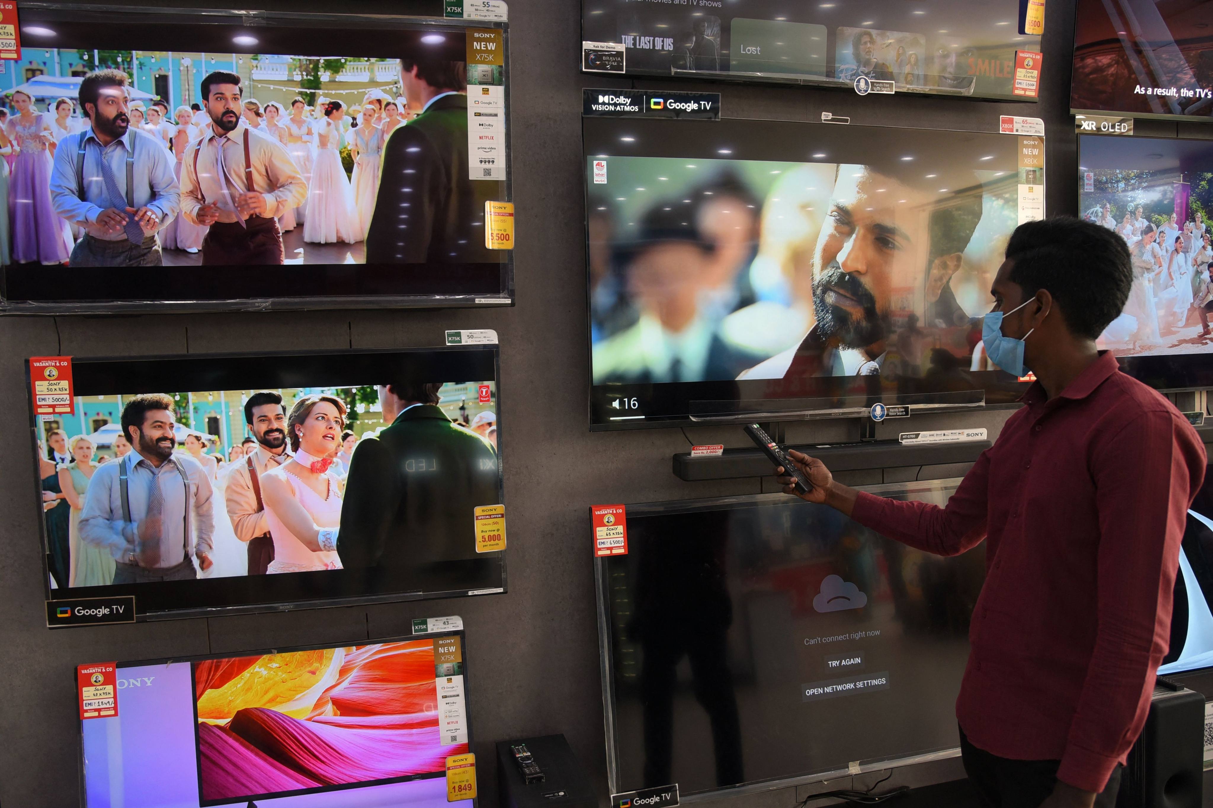 A man plays the Oscar-winning song “Naatu Naatu” from Indian film “RRR” at a TV showroom in Chennai. Photo: AFP