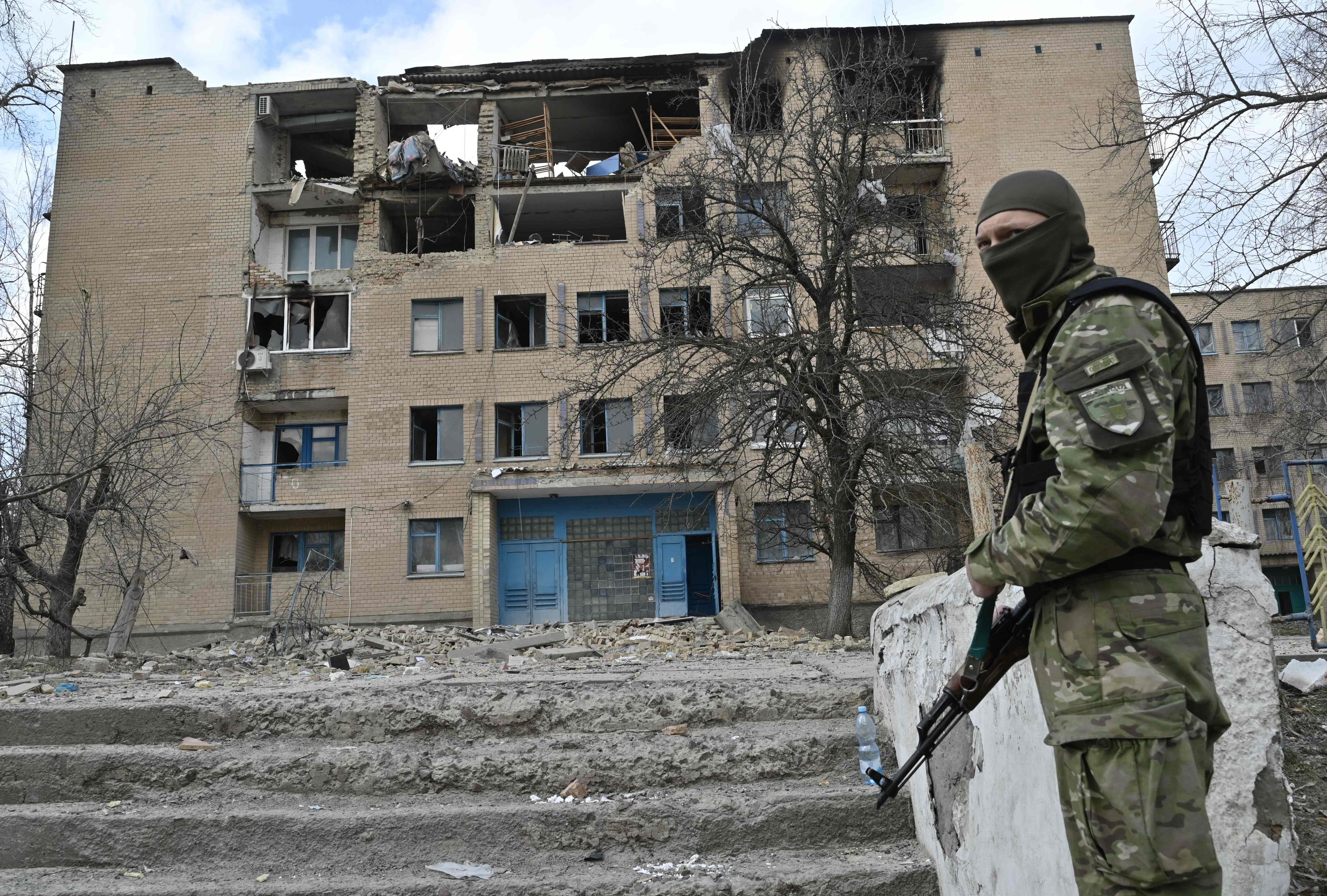 A Ukrainian police officer stands in front of a building hit by an air strike in the town of Rzhyshchiv, near Kyiv, on Wednesday, amid the Russian invasion of Ukraine. Photo: AFP