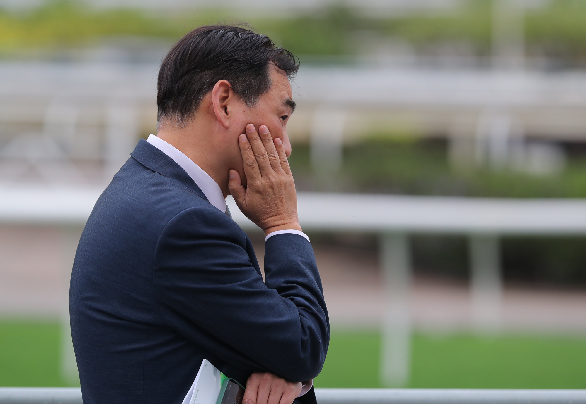 Michael Chang looks on after the fall involving jockey Keith Yeung and his horse, Felix The King.