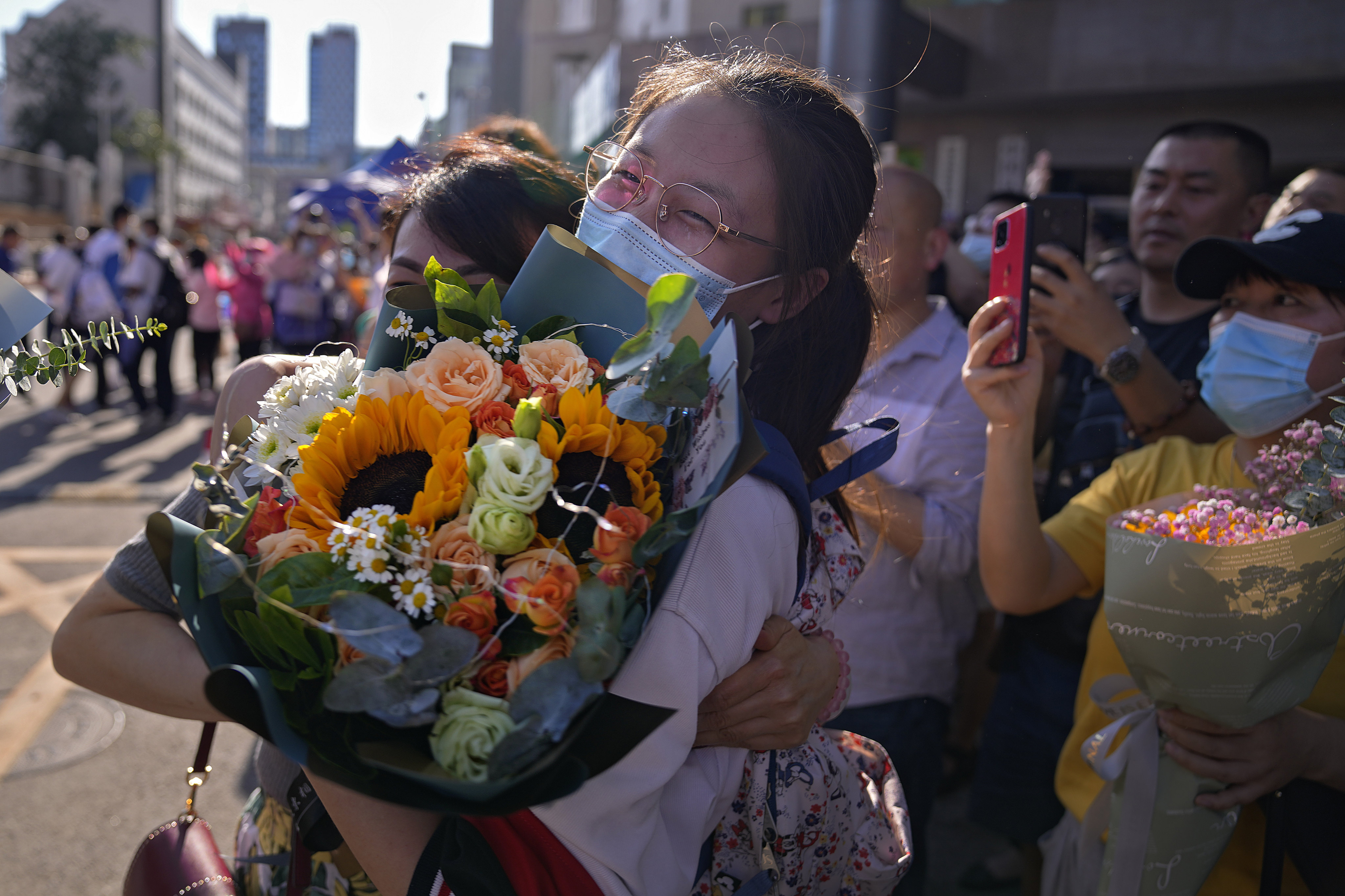 A student is hugged by her relative after completing China’s national college entrance exams in Beijing on June 10, 2021. Photo: AP