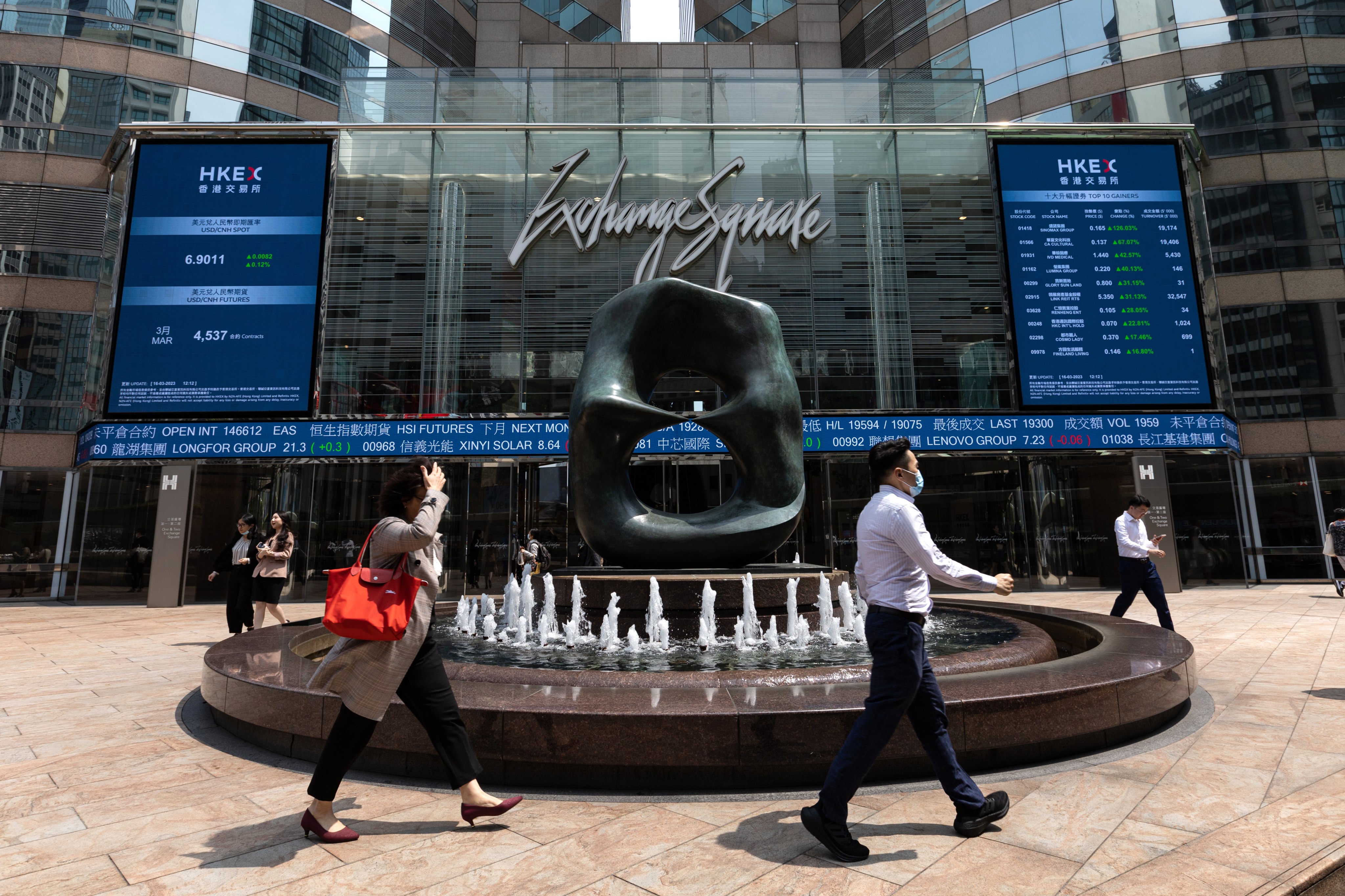 Pedestrians walk past a stock ticker outside Exchange Square, the building housing the stock exchange in Hong Kong. Declines in shares of Hong Kong-listed Chinese securities brokerages suggest concerns among traders about the firms’ gloomy revenue outlook. Photo: EPA-EFE