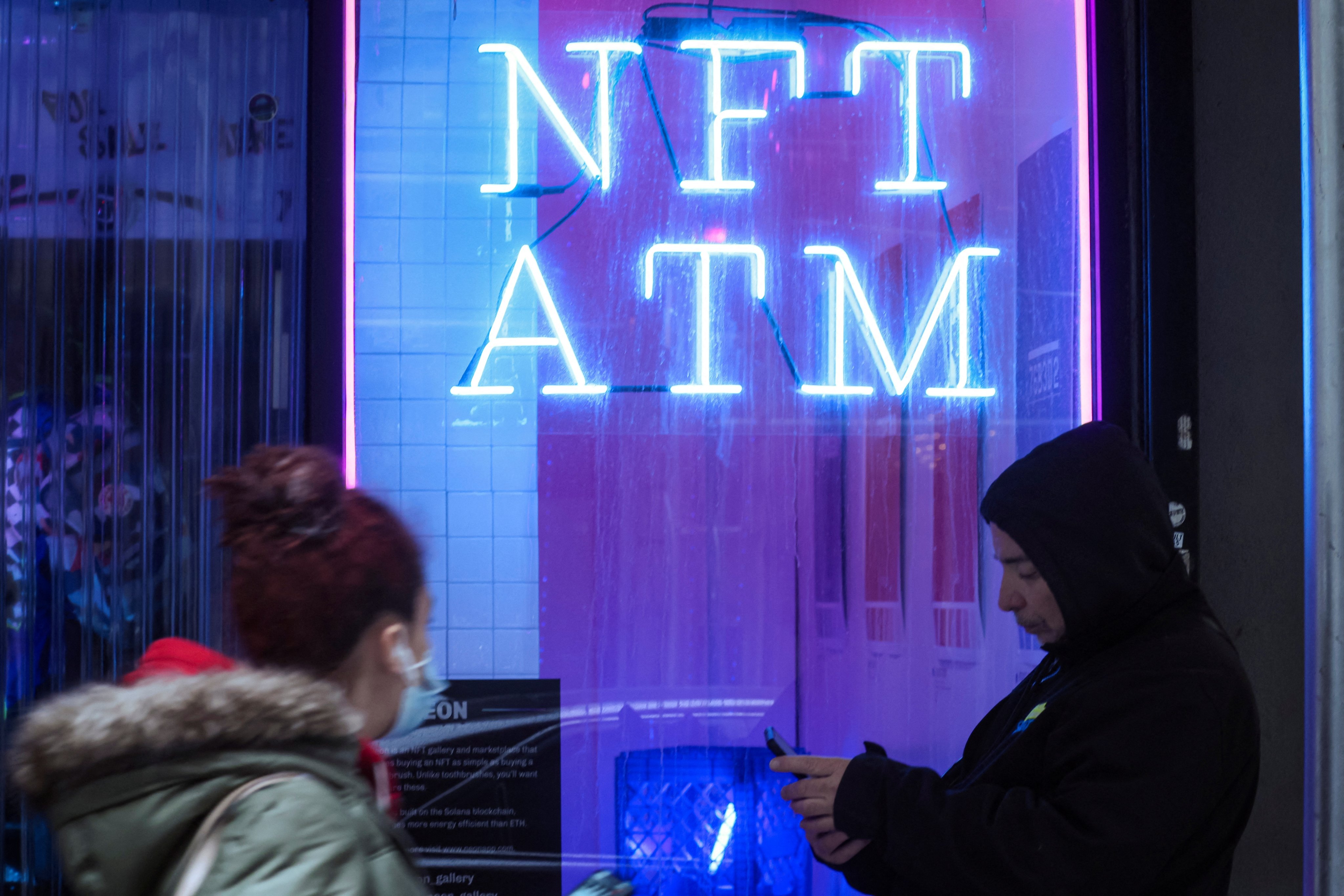 People pass by sign on a small shop that hosts digital art collecting platform Neon’s first in-person NFT vending machine in Lower Manhattan’s financial district, New York City, US, on March 1, 2022. Photo: Reuters