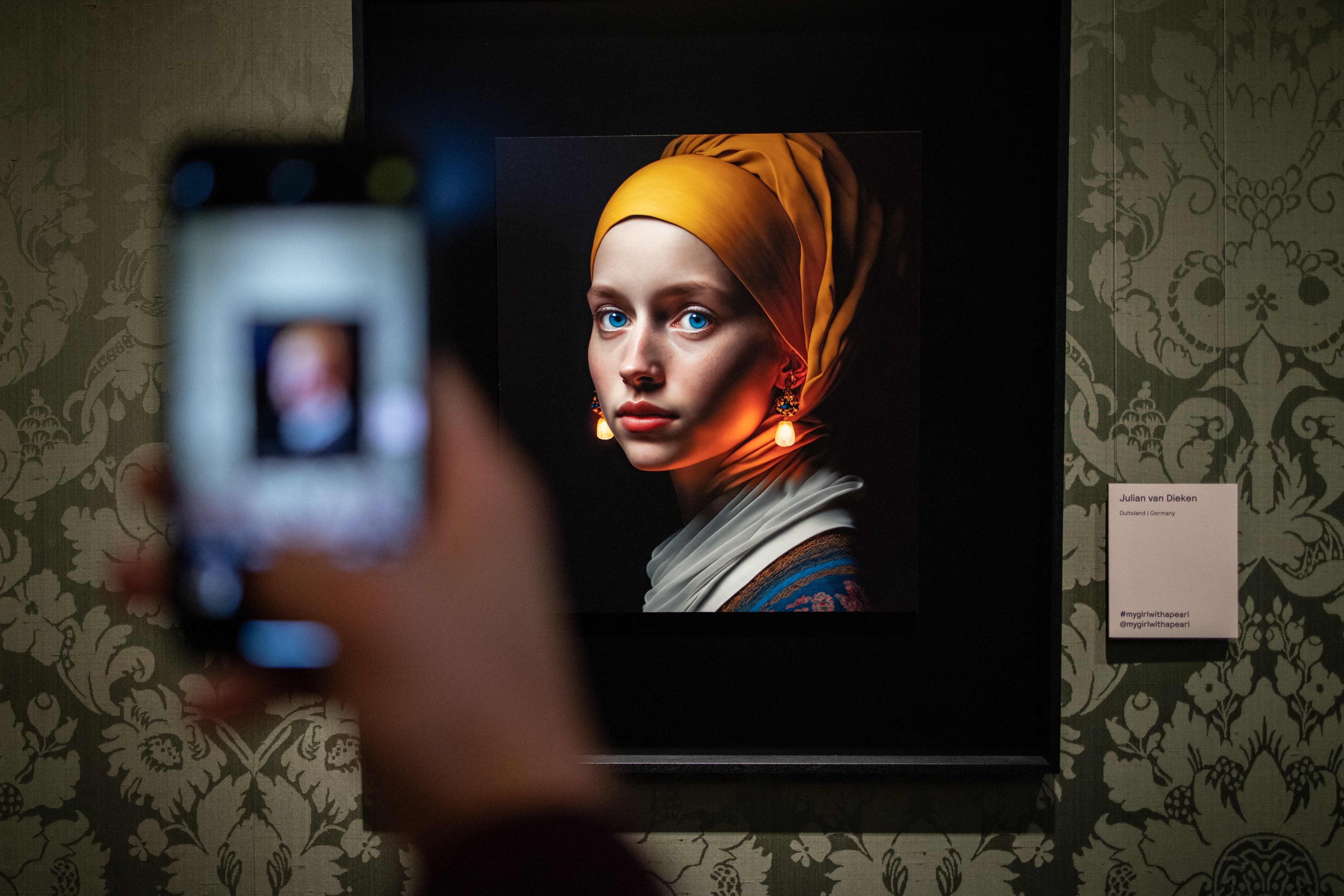 A visitor takes a picture with his mobile phone of an image designed with artificial intelligence by Berlin-based digital creator Julian van Dieken inspired by Johannes Vermeer’s painting “Girl with a Pearl Earring” at the Mauritshuis museum in The Hague on March 9. Photo: AFP