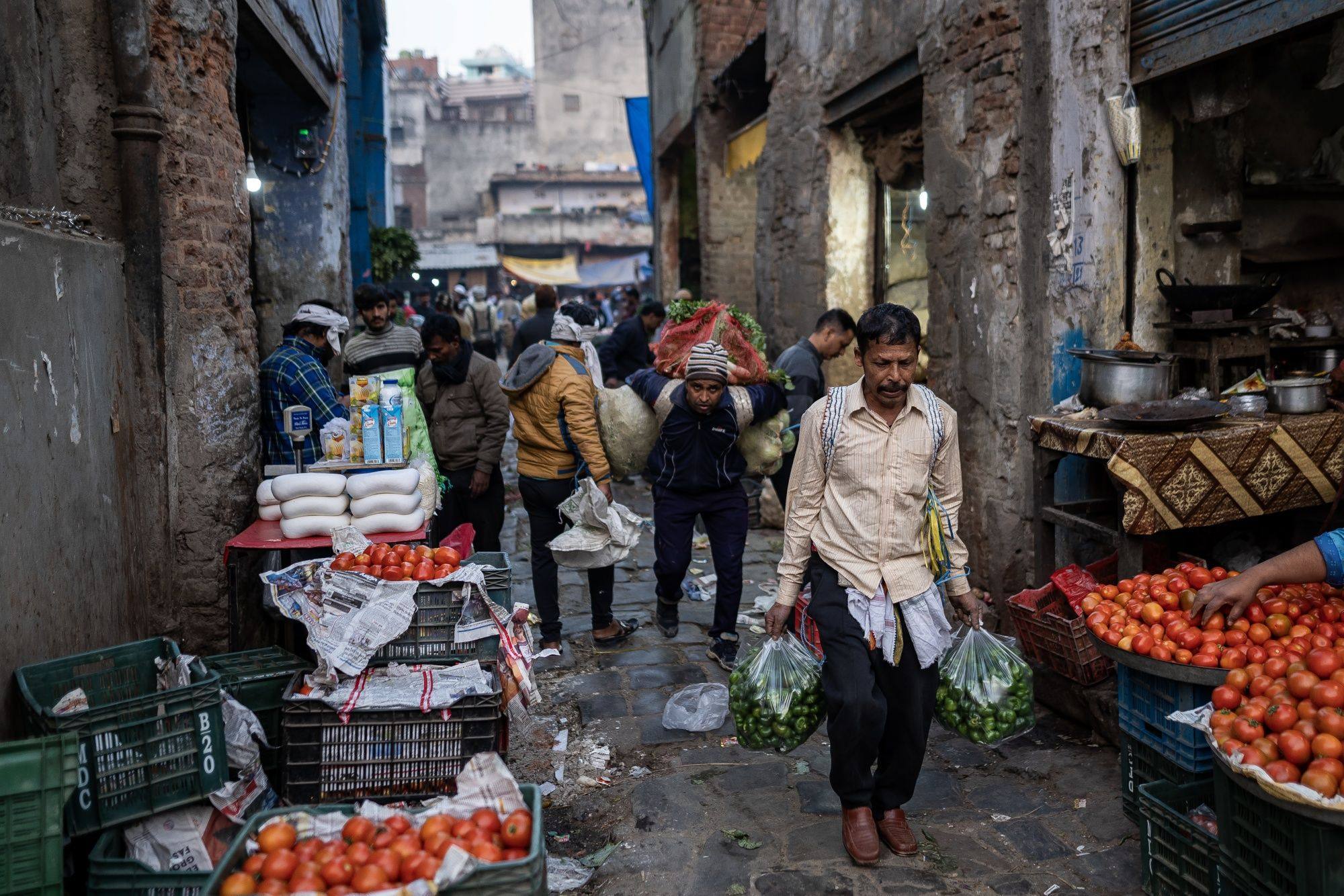 Workers carry sacks and bags of vegetables from a market in New Delhi, India, on February 26. The hype about an “Indian century” is masking a problem that has grown in the 75 years since independence: anaemic job creation. Photo: Bloomberg