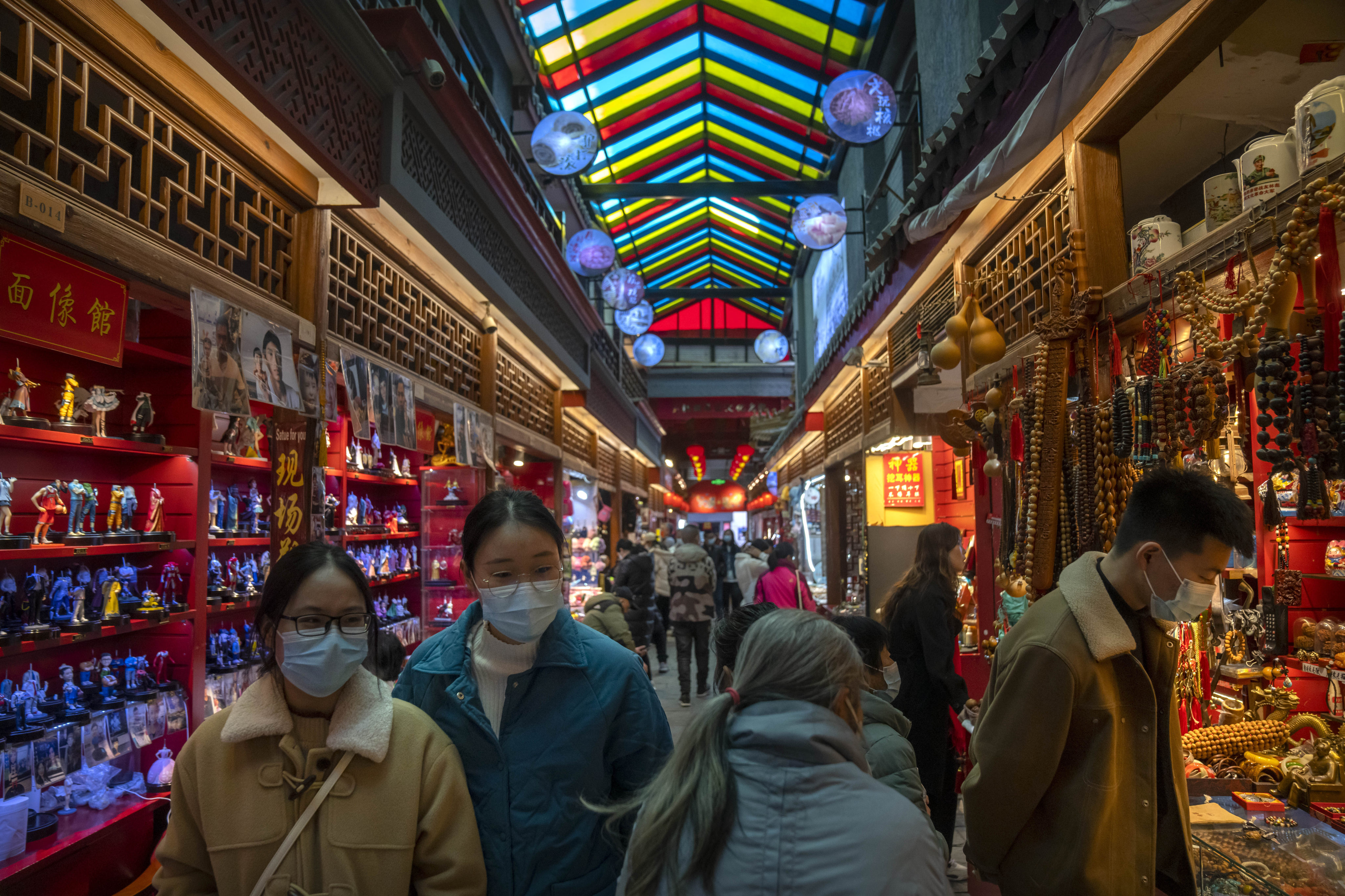 Visitors look at shops selling trinkets and souvenirs along a tourist shopping street in Beijing on February 28. China’s recovery is largely driven by a rebound in consumption and this counter-trend recovery can play a key role in supporting Asia’s growth. Photo: AP