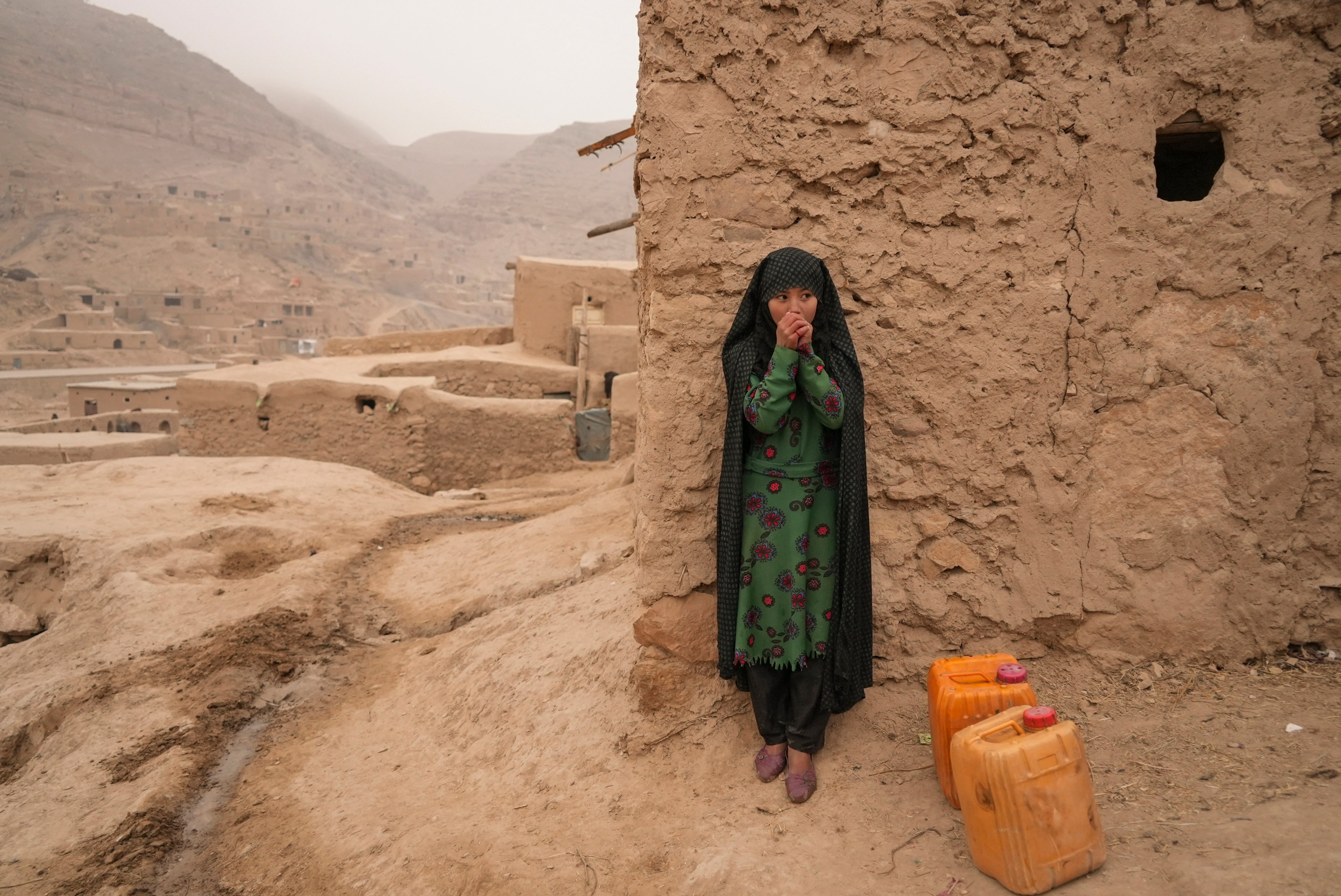 An Afghan girl warms up her hands as she rests from carrying the water in Balucha, Afghanistan, on December 14, 2021. The effects of climate change on women and girls are an increasingly pressing concern, as shown by a recent case before the European Court of Human Rights. Photo: AP