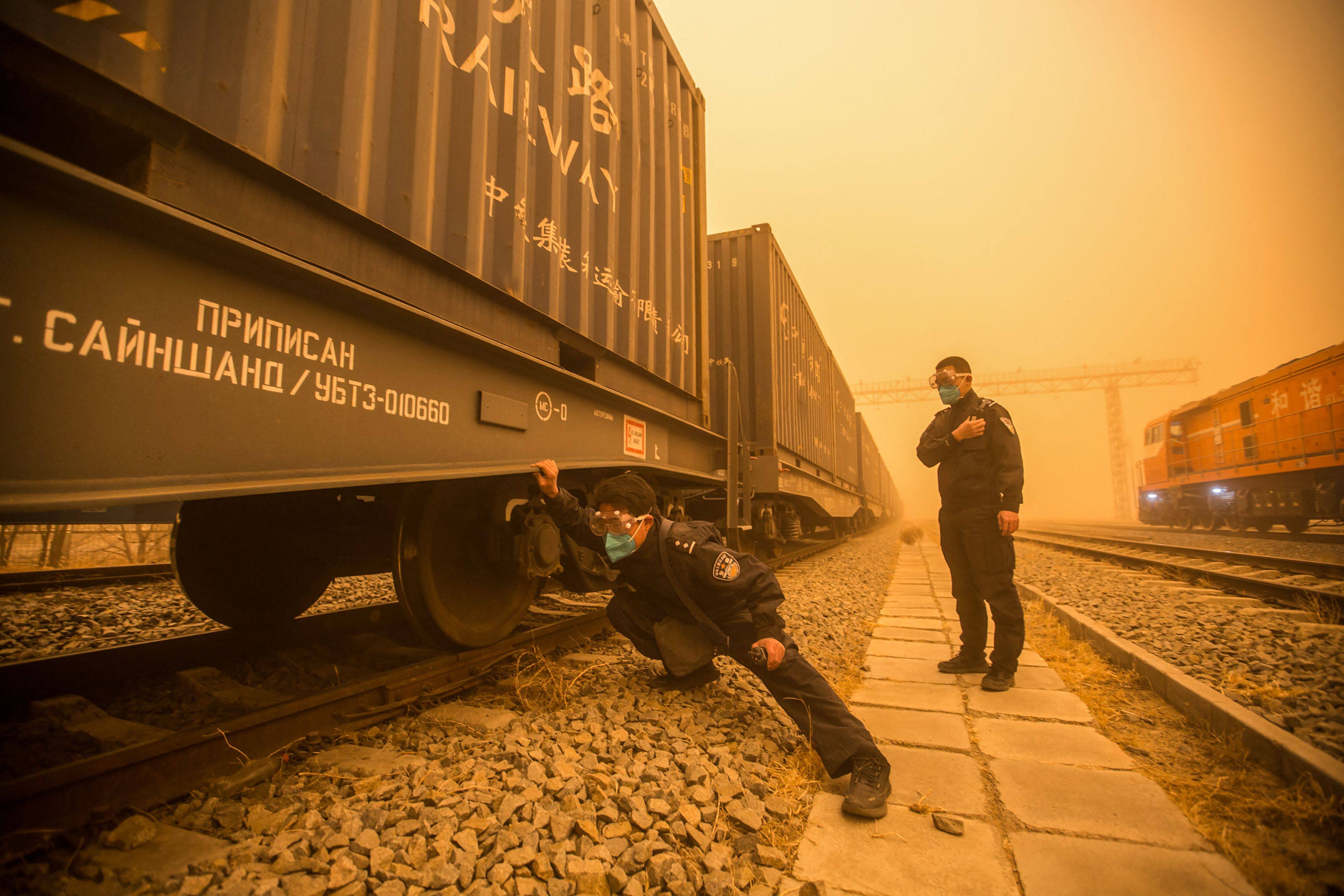A police officer checks train cars at a border checkpoint during a sandstorm in the border city of Erenhot in China’s northern Inner Mongolia region. Landlocked between China and Russia, Mongolia gets much of its electricity from Russia, and China buys much of its exports. Photo: AFP