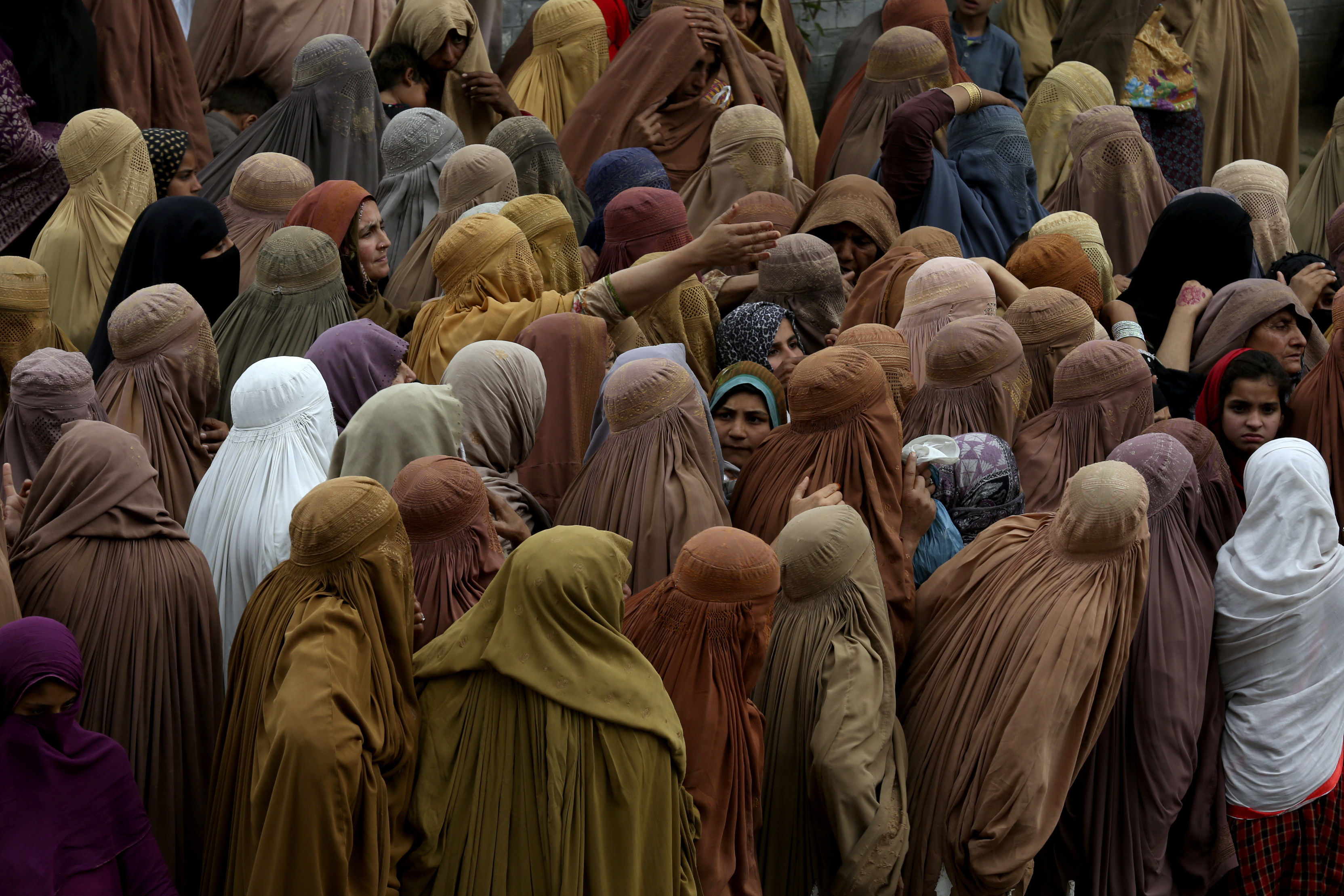 Women gather for a free sack of wheat flour at a distribution point in Peshawar, Pakistan. Photo: AP
