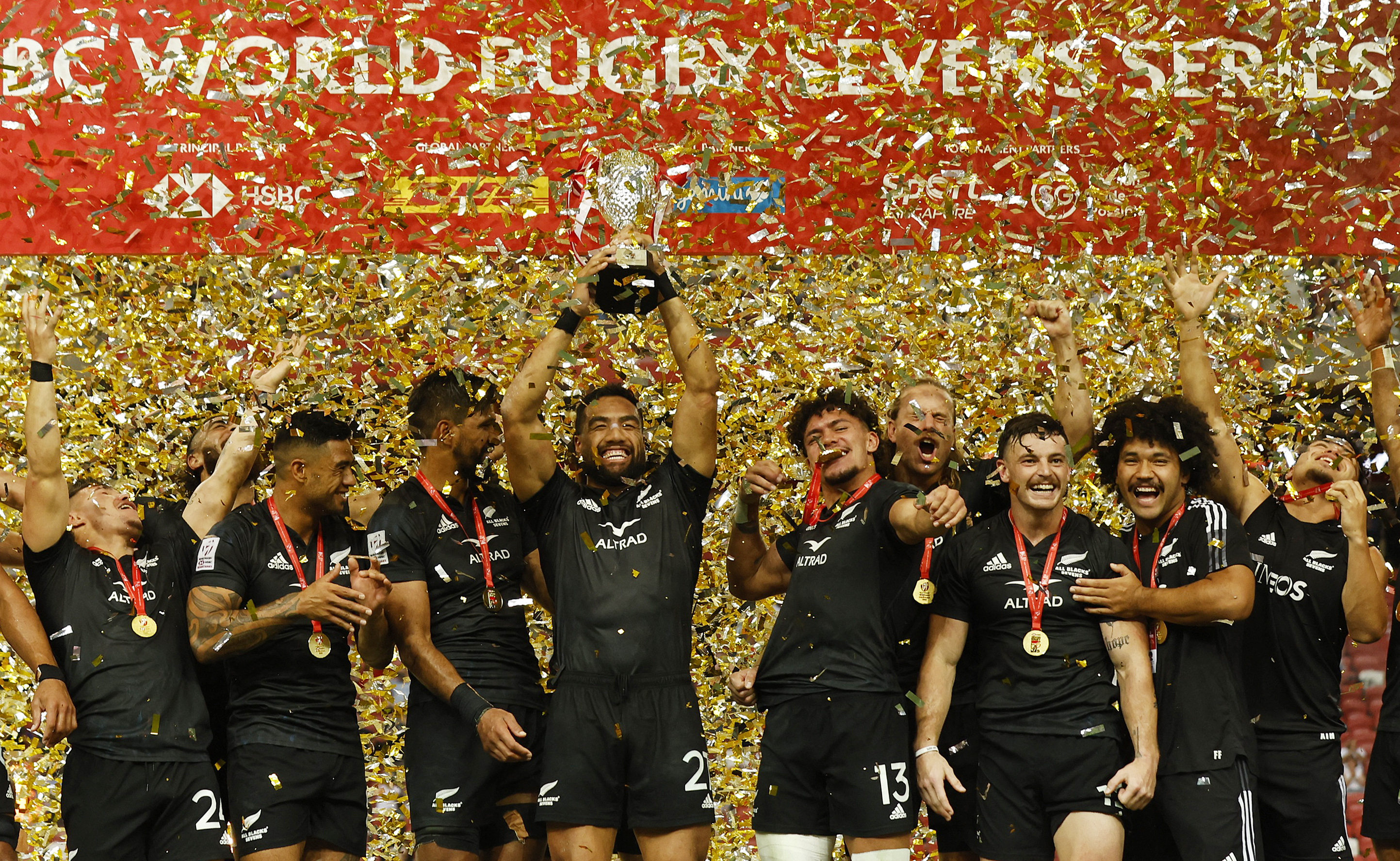 New Zealand players celebrate winning the Singapore Sevens Cup final with the trophy. Photo: Reuters