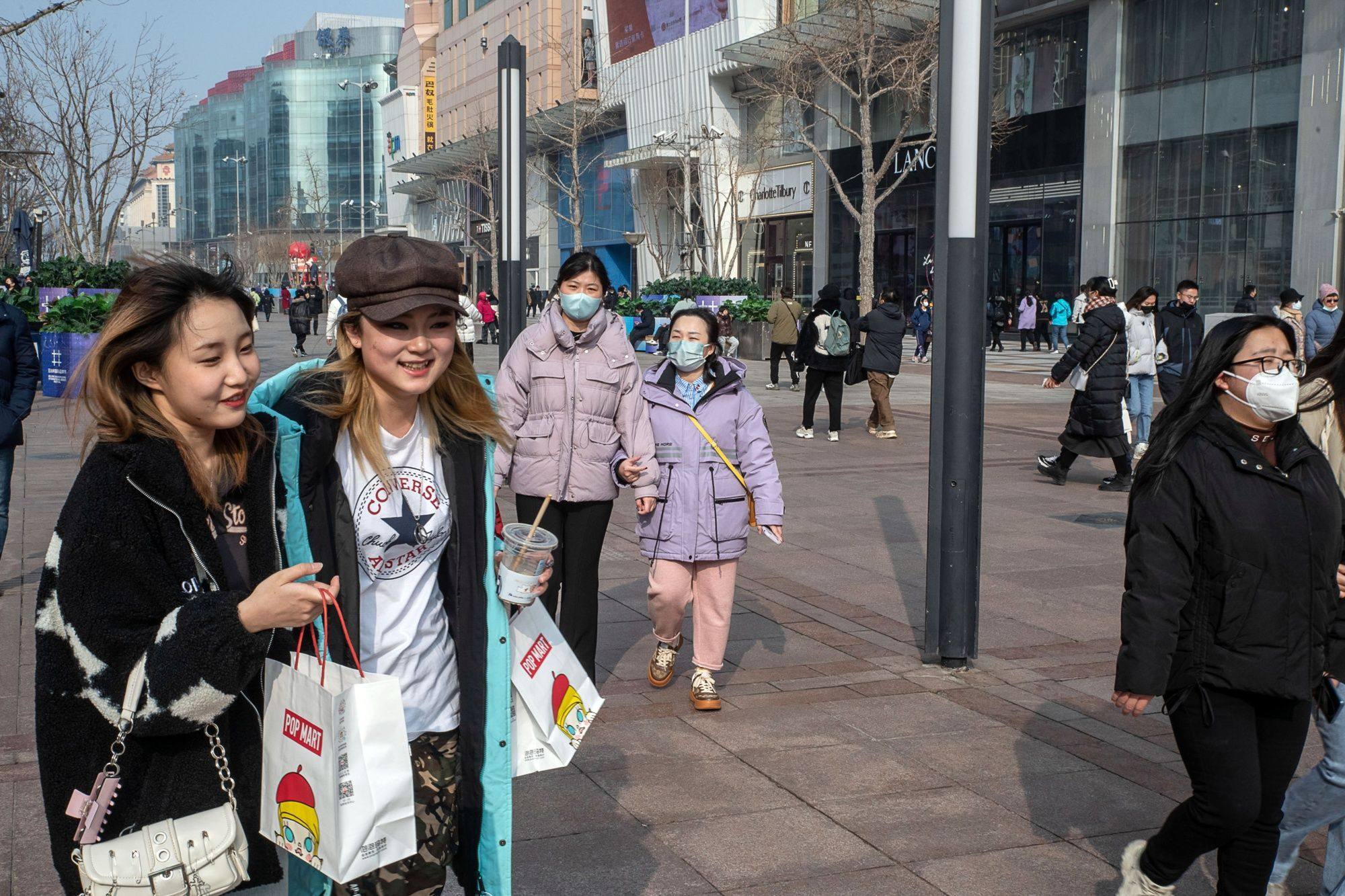 Pedestrians pass through the Wangfujing shopping area in Beijing on February 10. The proliferation of risks and tightening of financial conditions are taking a toll on business and consumer confidence and investment, but China is a bright spot. Photo: Bloomberg