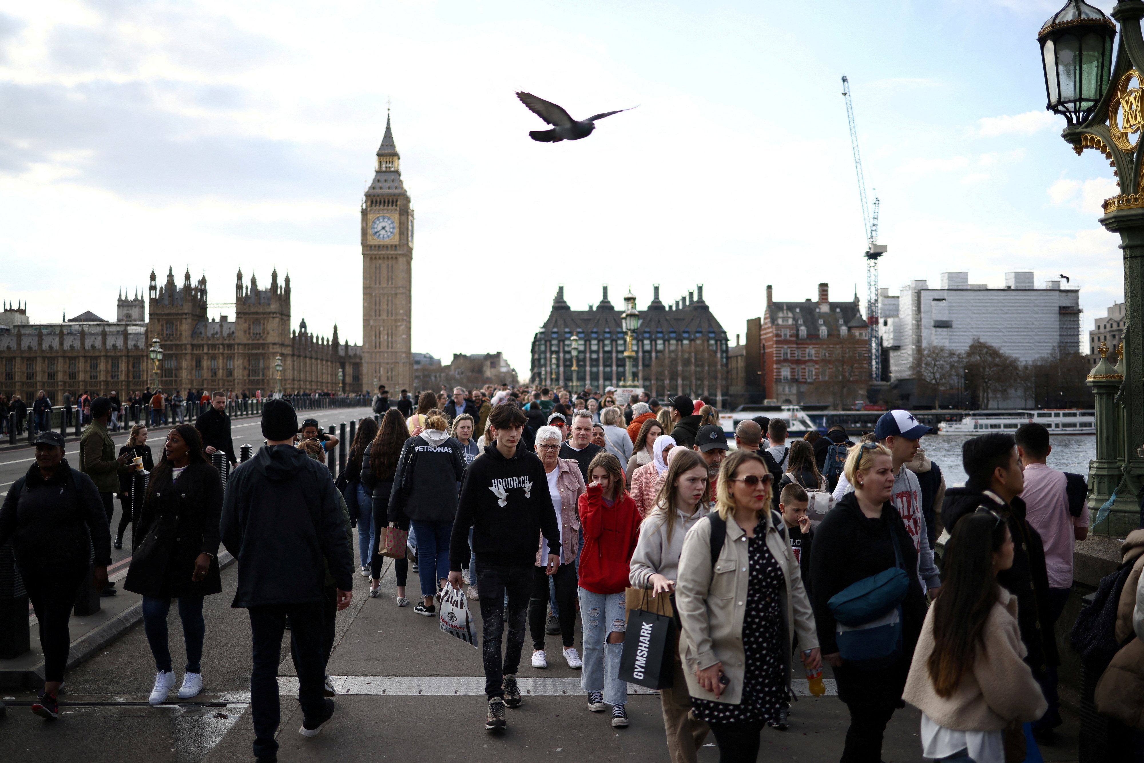 People walk over Westminster Bridge near the Houses of Parliament in London. Photo: Reuters