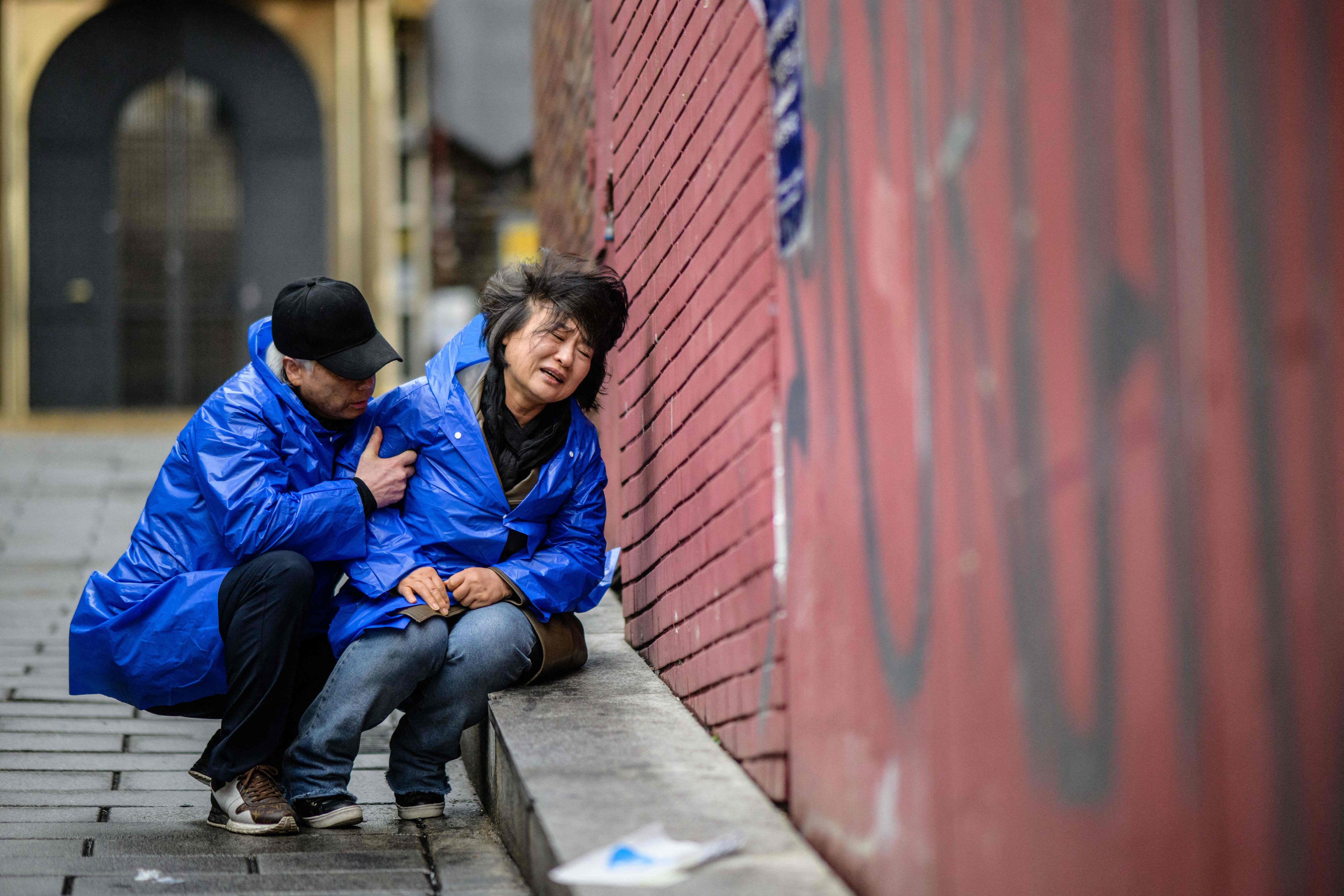 Cho Mi-eun cries as her husband Lee Jong-chul kneels down to comfort her in the alleyway where their 24-year-old son was killed in the crowd crush in Itaewon, Seoul, in October. Photo: AFP