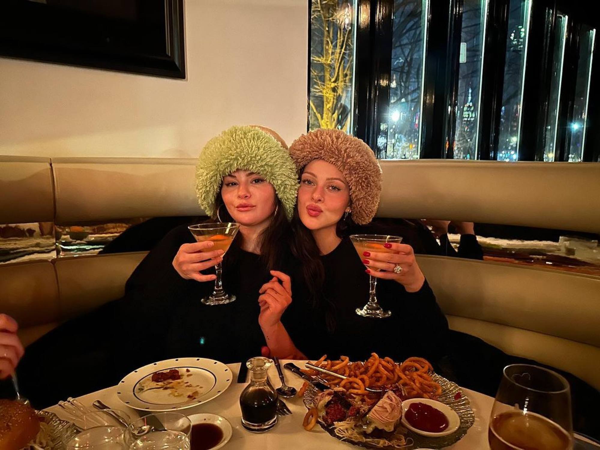 Selena Gomez and Nicola Peltz wearing matching furry hats on February 11. Photo: @nicolaannepeltzbeckham/Instagram