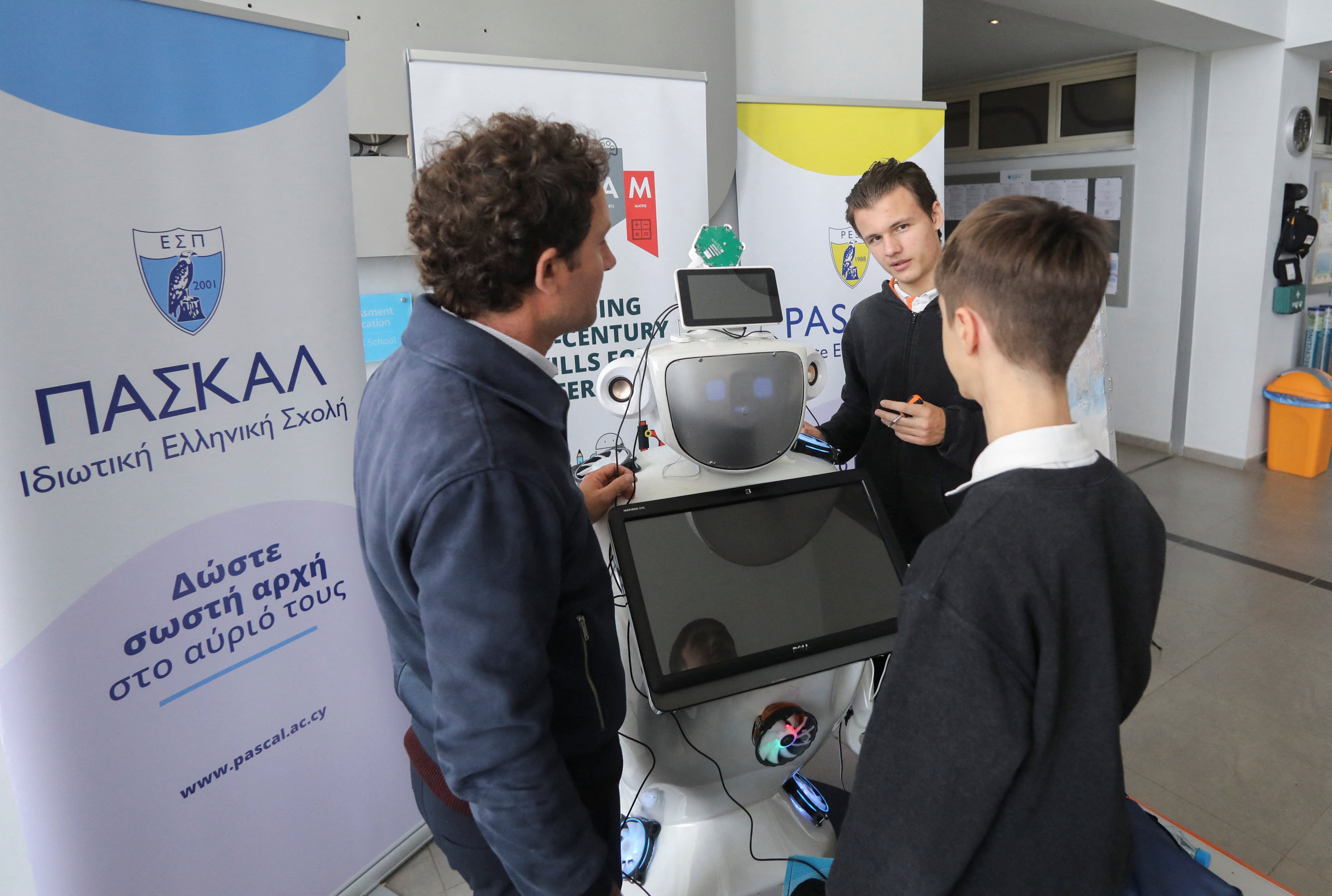Project leader Elpidoforos Anastasiou and high school students Richard Erkhov and Vladimir Baranov work on “Alnstein”, a robot powered with ChatGPT, in Pascal school, in Nicosia, Cyprus, on March 30. Photo: Reuters