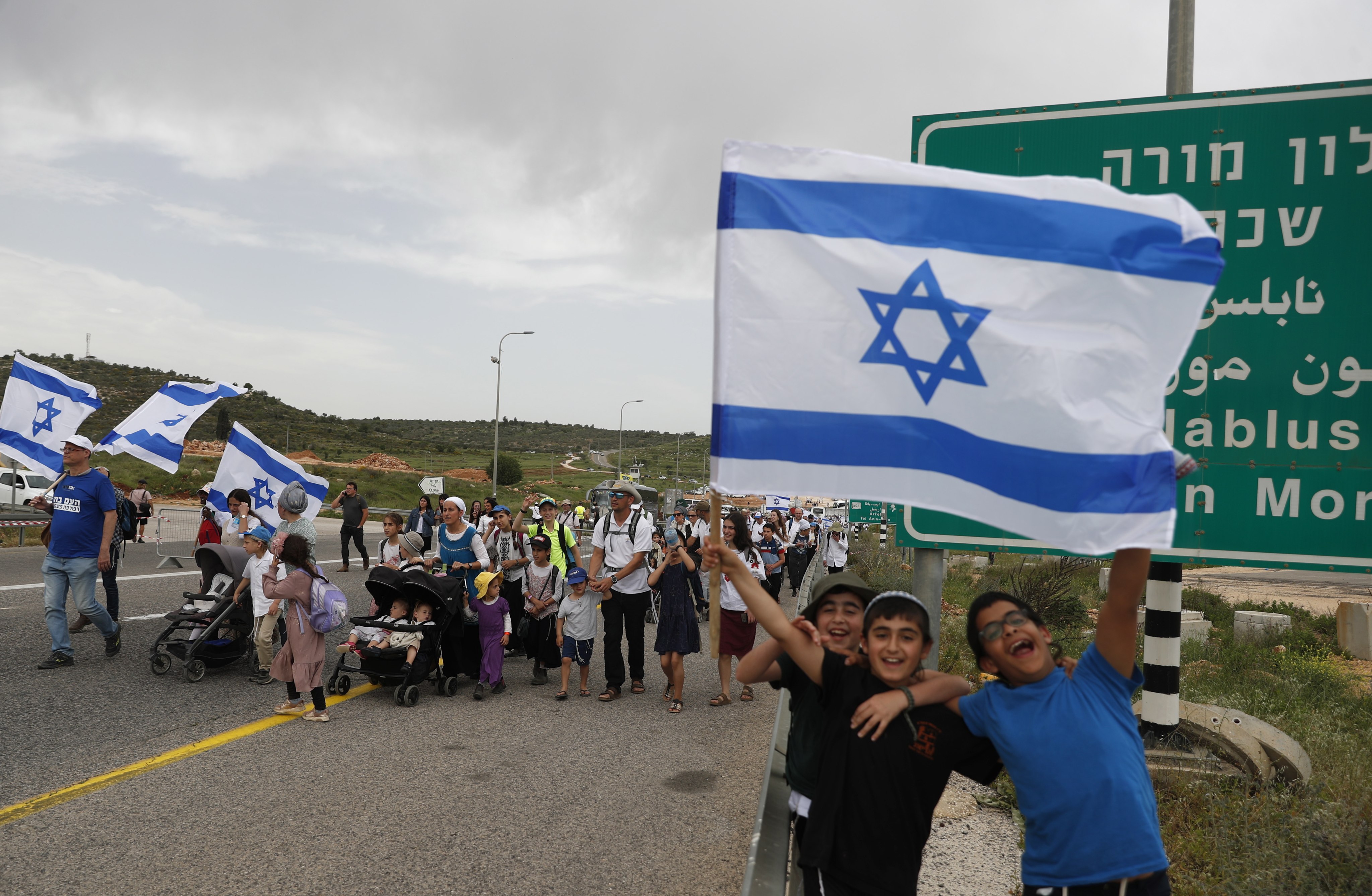 Israeli far-right supporters wave national flags as they march during a rally near the illegal outpost of Avitar, near the West Bank city of Nablus, on Monday. Photo: EPA-EFE