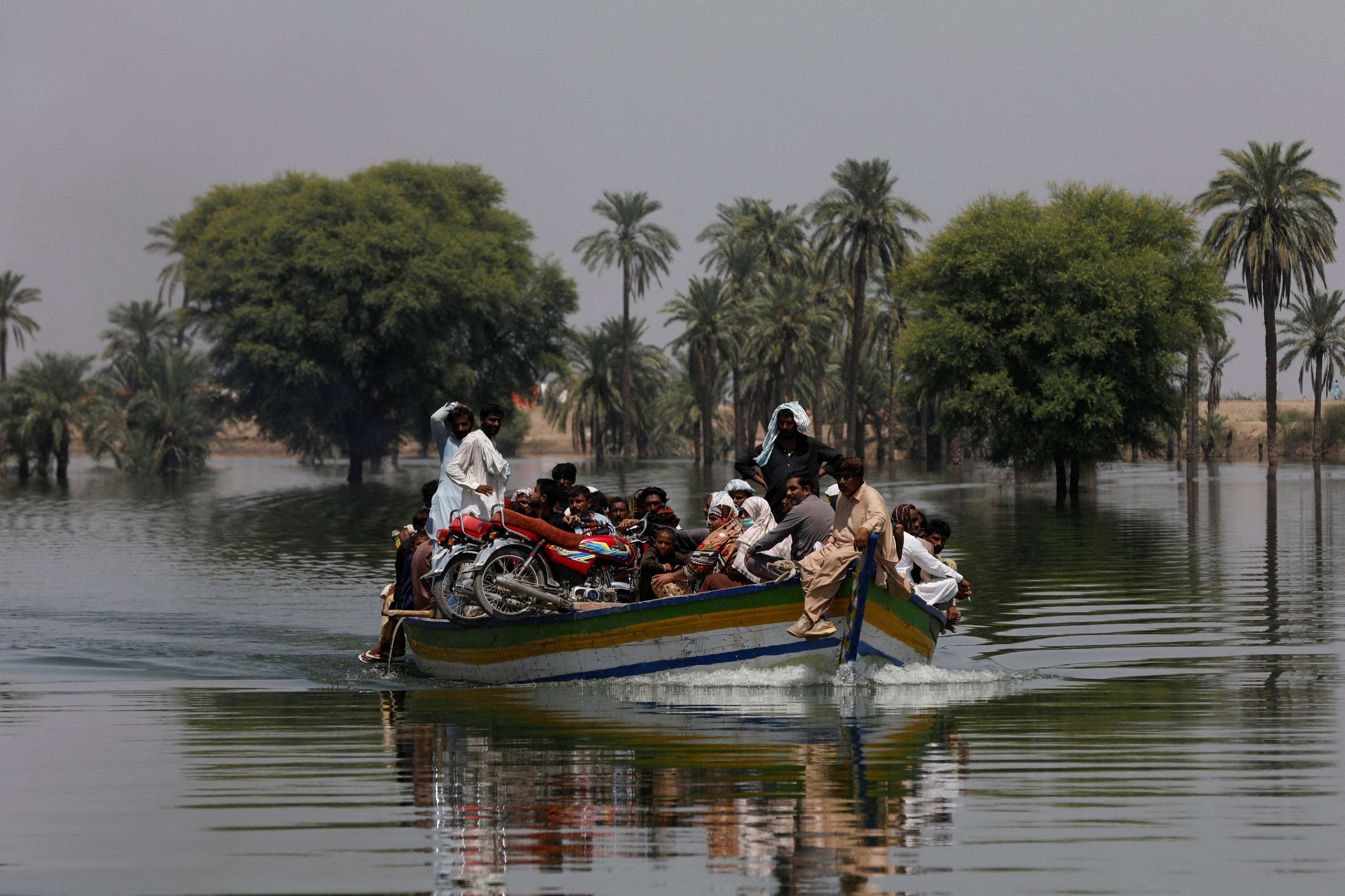 Flood victims in Pakistan travel in a boat, following rains and floods during the 2022 monsoon season. 19 of the world’s 25 most exposed cities to a one-metre rise in sea levels are in Asia. Photo: Reuters