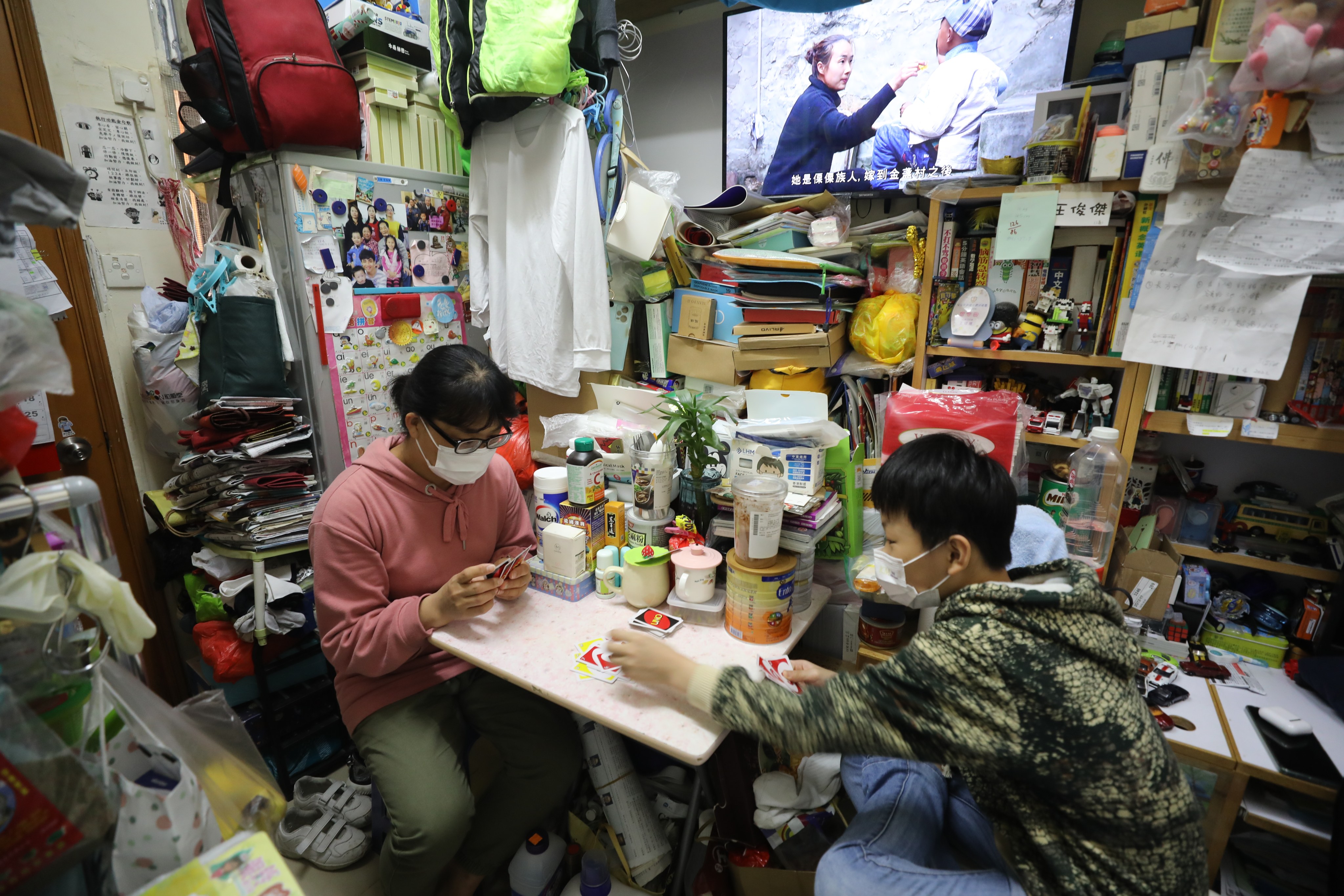 A woman and her son play a card game in their subdivided flat home in Sham Shui Po on February 4. Over 80 per cent of subdivided flats are located in buildings over 50 years old. Photo: Xiaomei Chen