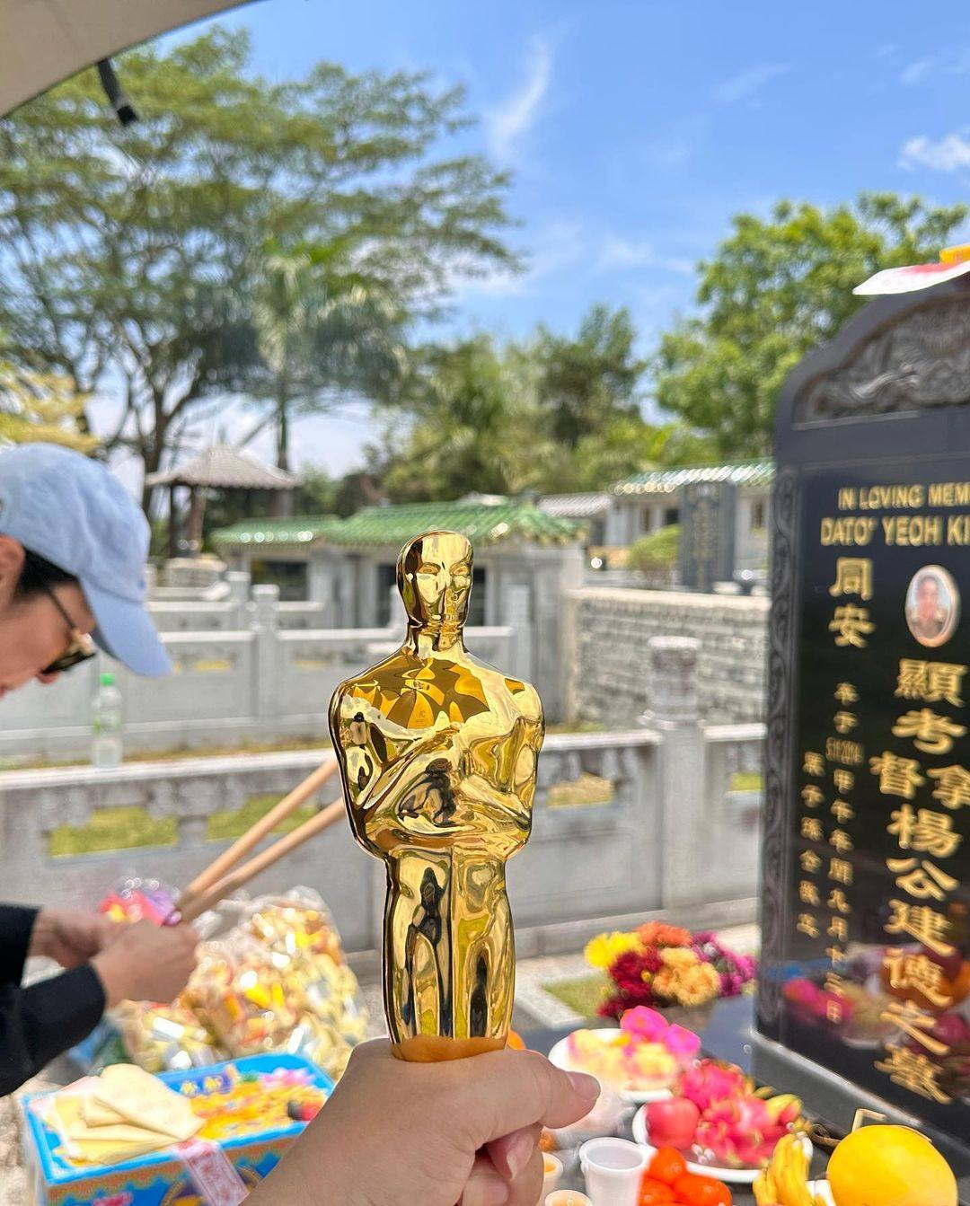 Actress Michelle Yeoh holds the Oscar trophy next to her late father’s grave. Photo: Instagram/michelleyeoh_official