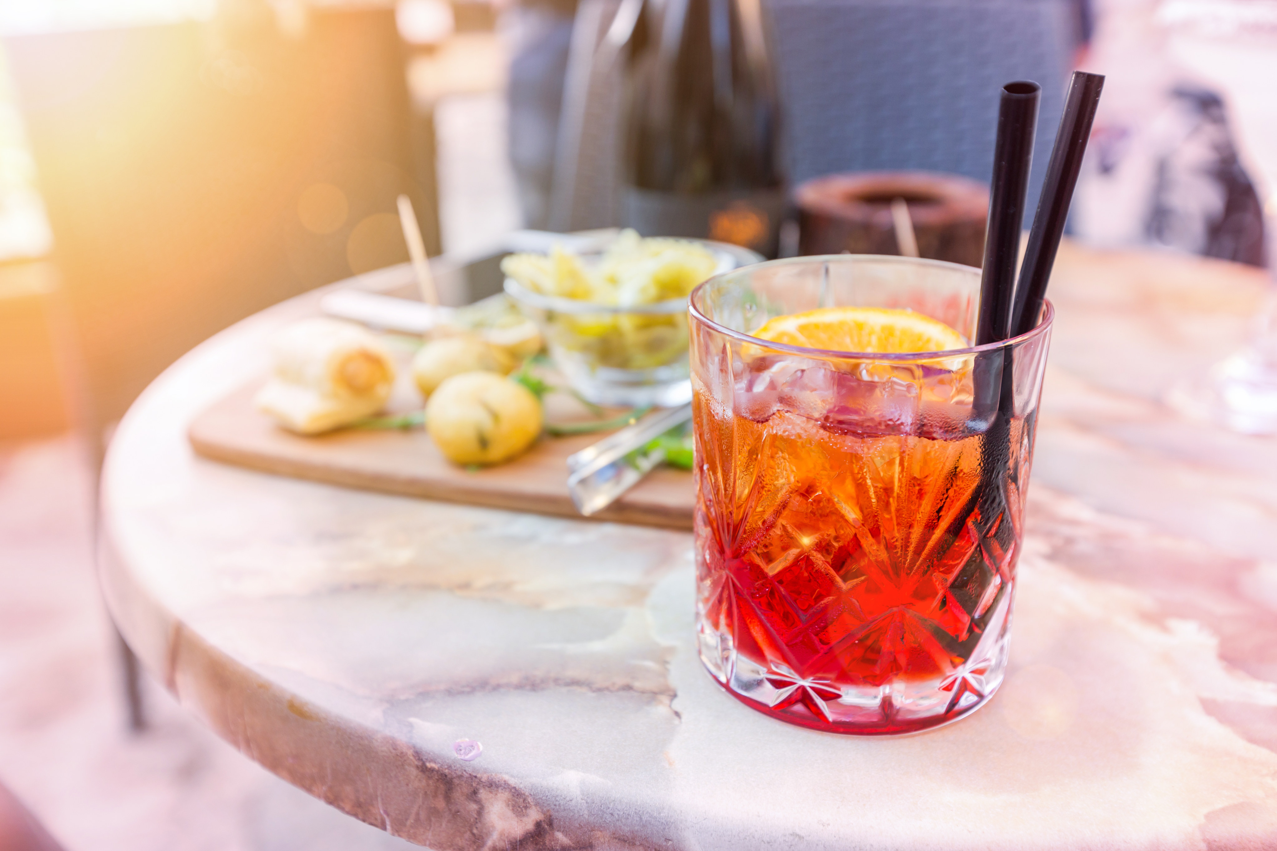 Mezcal Negroni cocktail Italian aperitivo on the table in the open area of restaurante. Photo: Getty Images