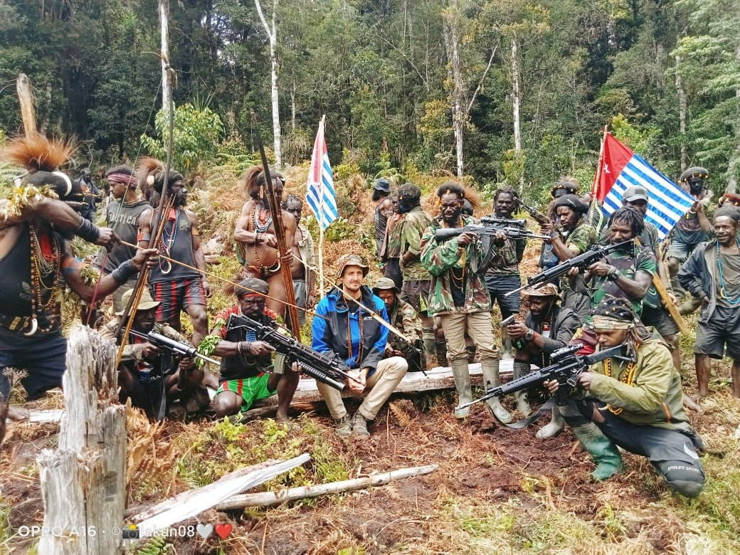 A man identified as Philip Mehrtens, the New Zealand pilot said to be held hostage by a pro-independence group, sits among separatist fighters in Indonesia’s Papua region in March. Photo: The West Papua National Liberation Army via Reuters