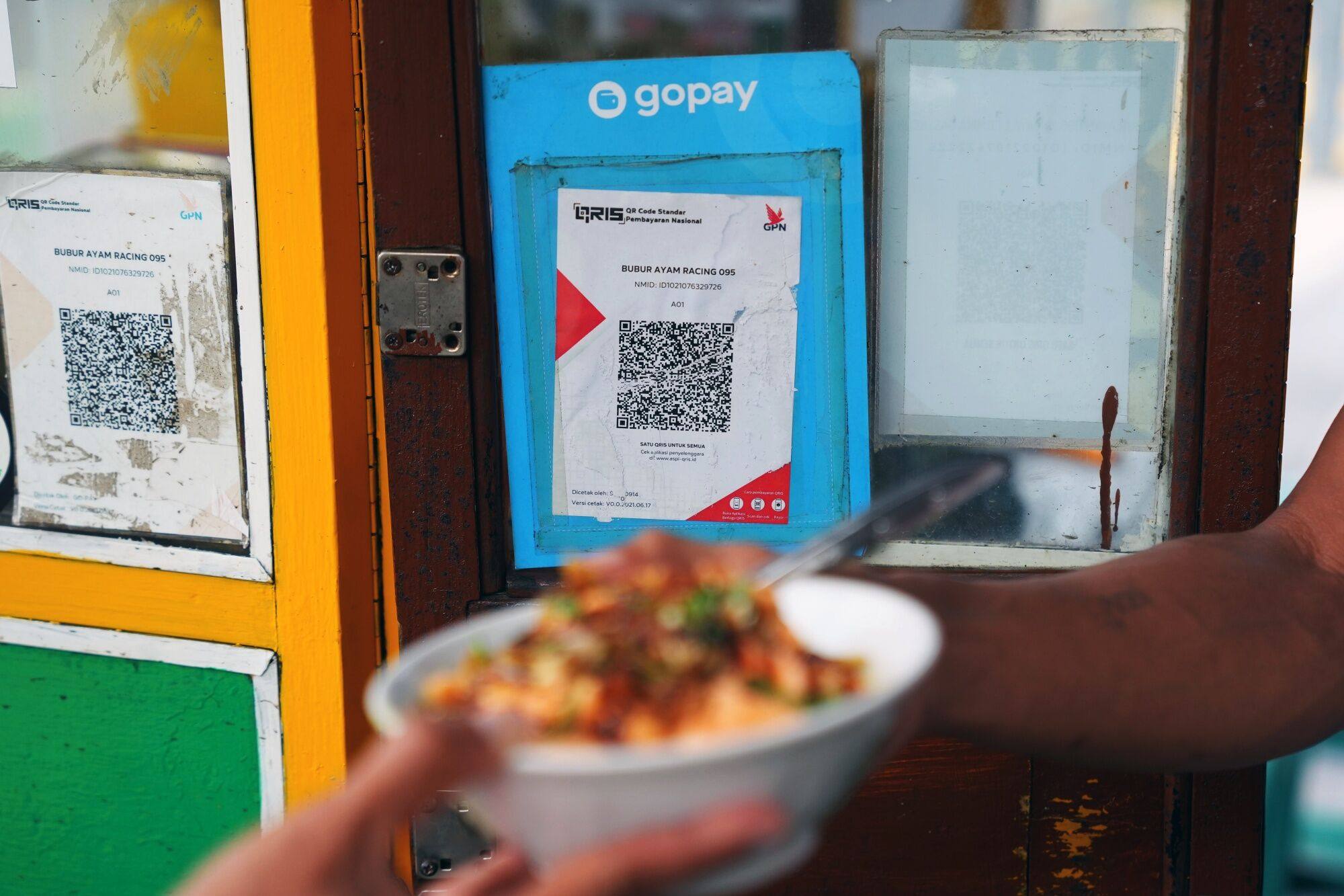 A QR code for mobile payment is displayed at a street food vendor in Jakarta on February 13. The uptake of QR codes and mobile payments is paving the way for Indonesia to capture billions of dollars of informal economic activity overlooked in taxation and even statistics amid small businesses’ reliance on cash. Photo: Bloomberg