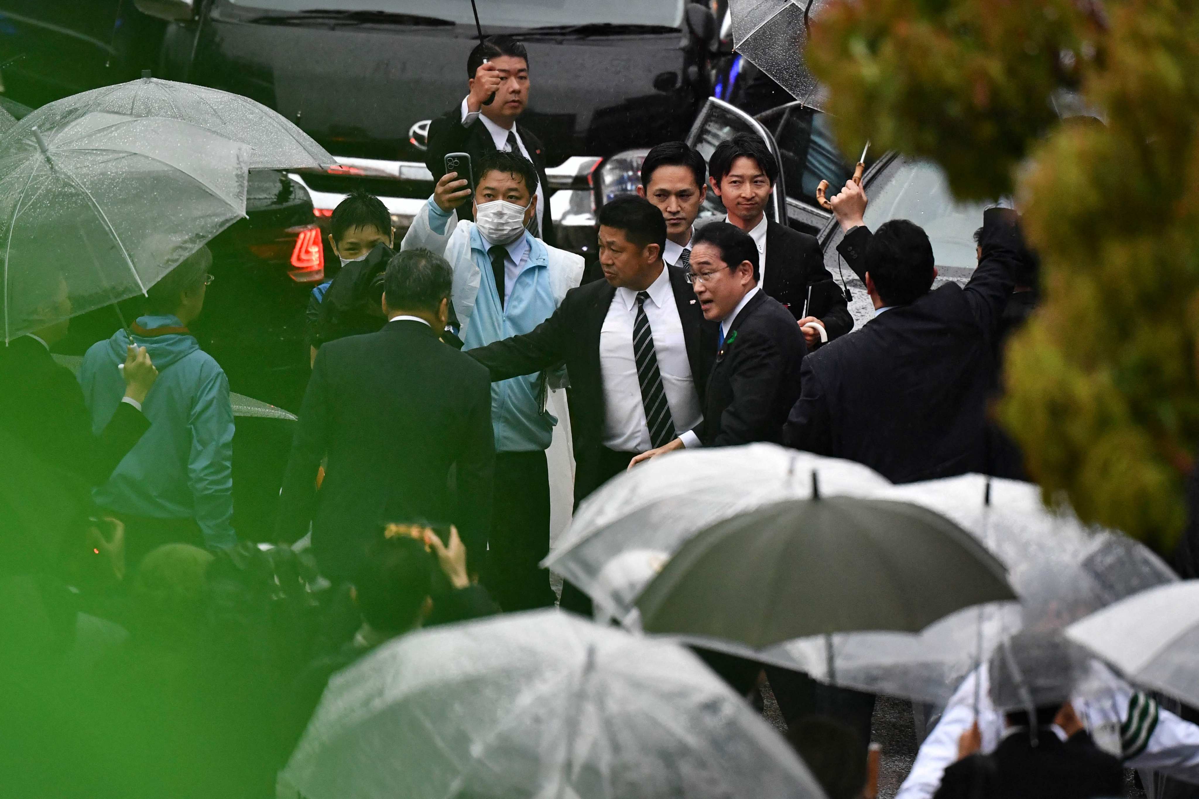 Japan’s Prime Minister Fumio Kishida is escorted by security officers at an election campaign event in Chiba prefecture on Saturday, hours after being evacuated unharmed from the scene of an apparent “smoke bomb” blast at another event earlier that day. Photo: AFP