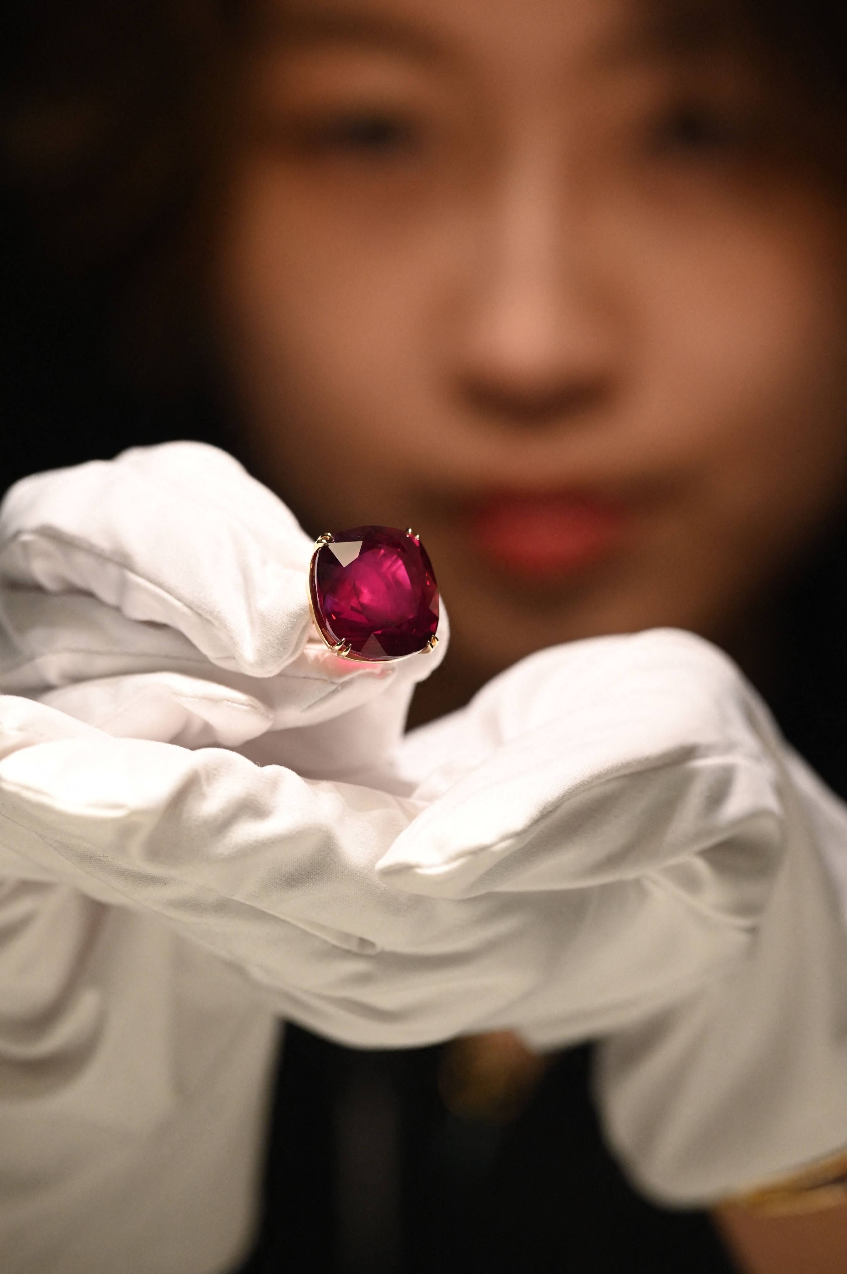 A representative from Sotheby’s Hong Kong holds up the Estrela de Fura Ruby in Hong Kong on April 17. Photo: AFP