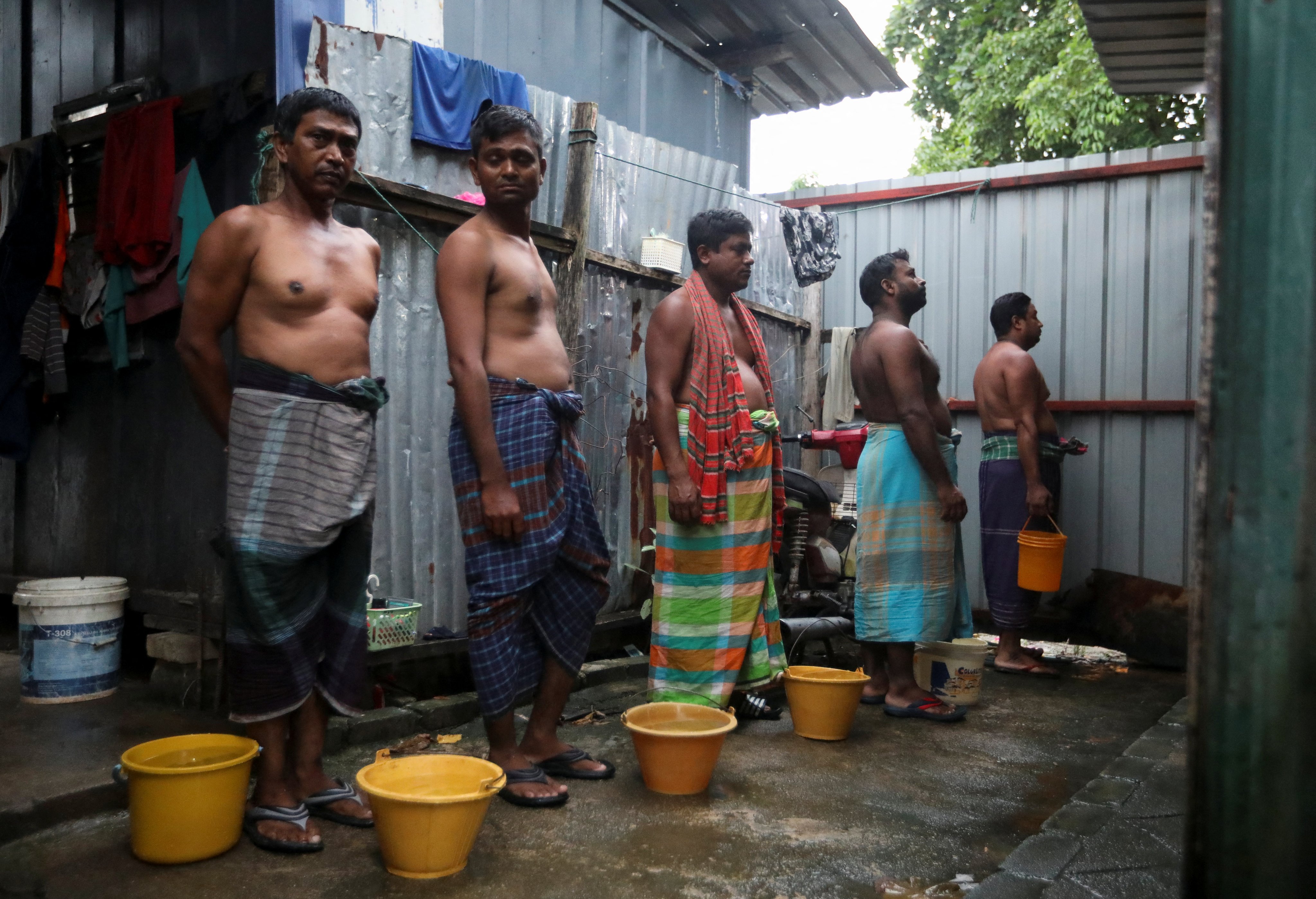 Migrant workers queuing to use one of four toilets shared among 104 construction workers in Kuala Lumpur, Malaysia last year. Photo: Reuters