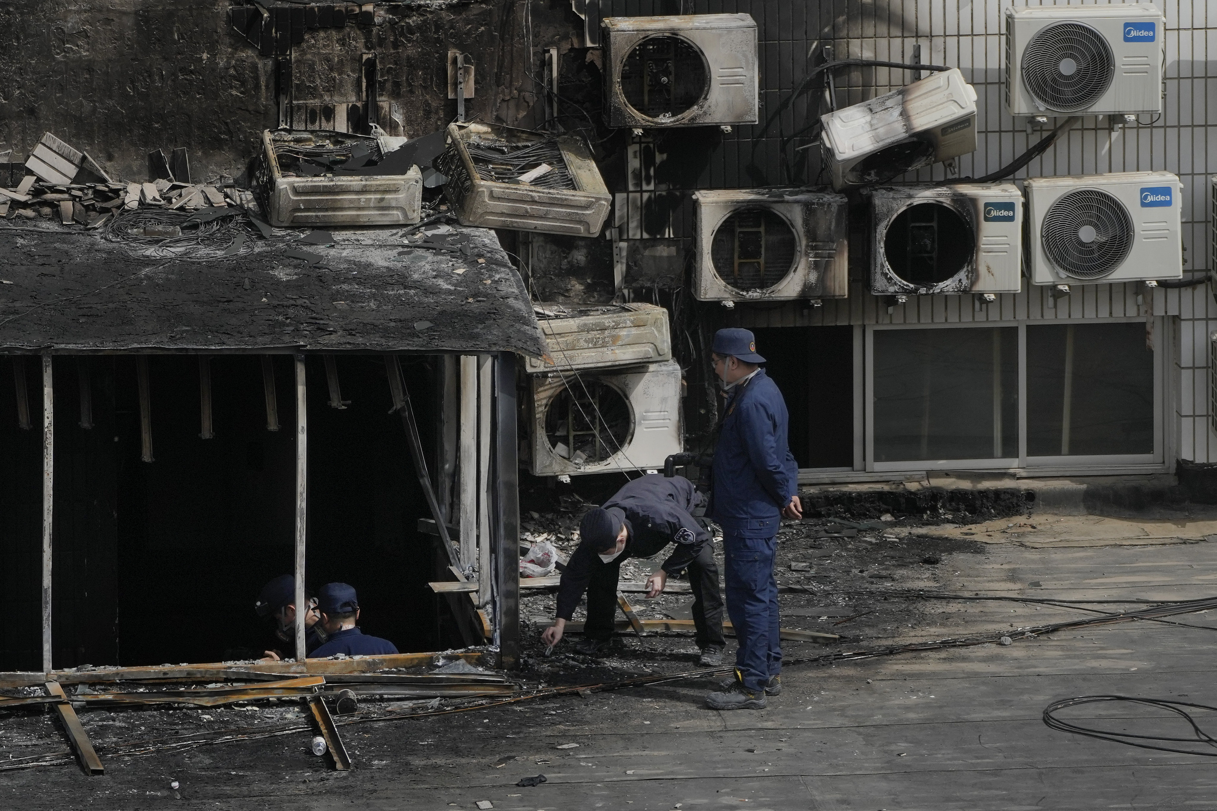 Investigators check out a burnt-out corridor at the Beijing Changfeng Hospital where a deadly fire broke out on Tuesday. Photo: AP