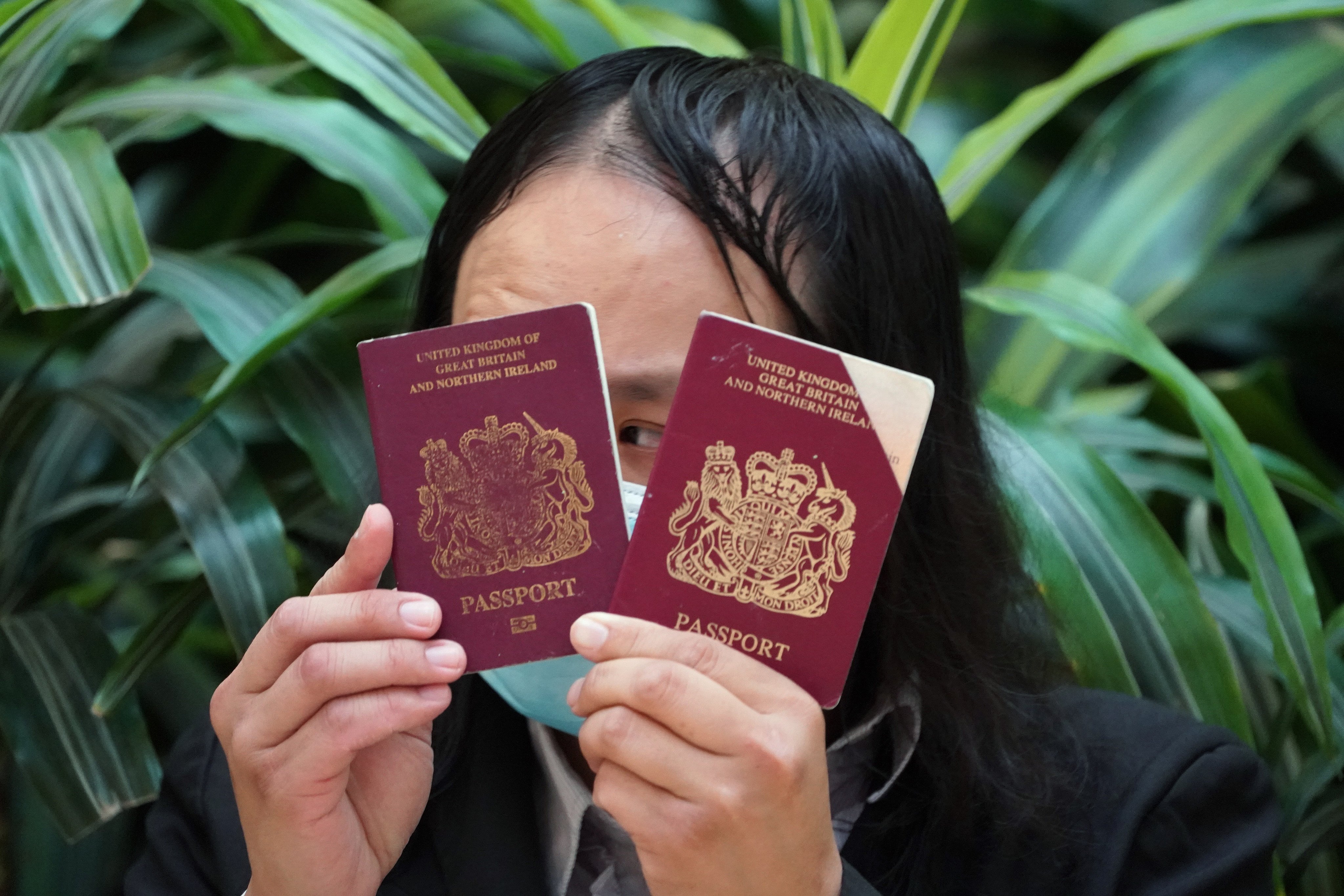 A protester holds a British National (Overseas) passport during a demonstration at Pacific Place in Admiralty on June 2, 2020. BN(O) passport holders abroad have raised concerns about being denied access to the funds in their Mandatory Provident Fund accounts in Hong Kong. Photo: Felix Wong