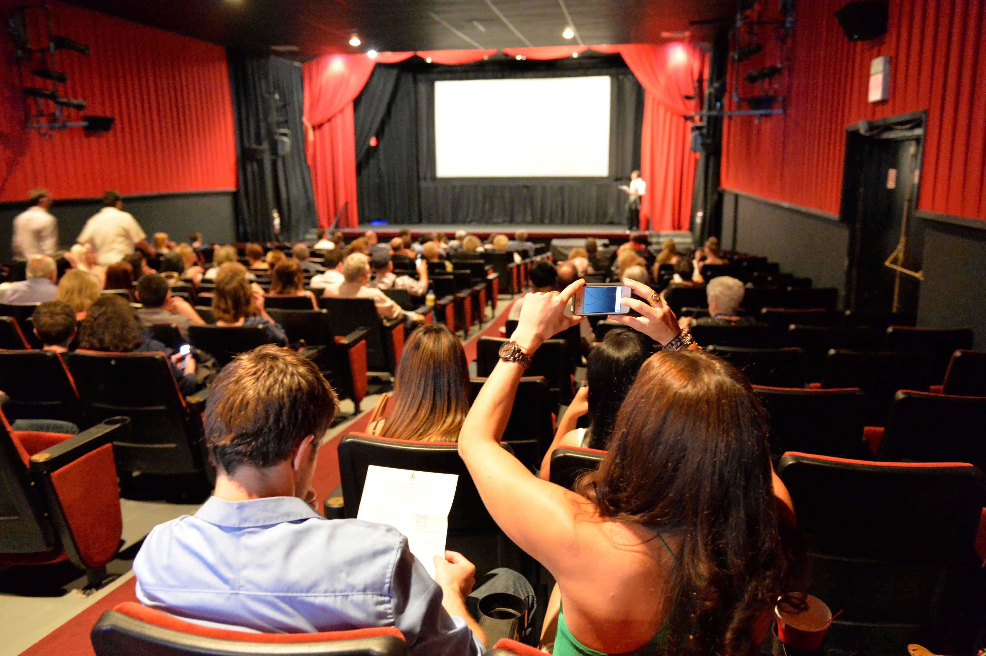 A woman takes a phone photo before the screening of film Halina during the Long Island International Film Expo in 2015. An author finds theatre etiquette so interesting she has written two books on the subject. Photo: ZUMAPRESS.com