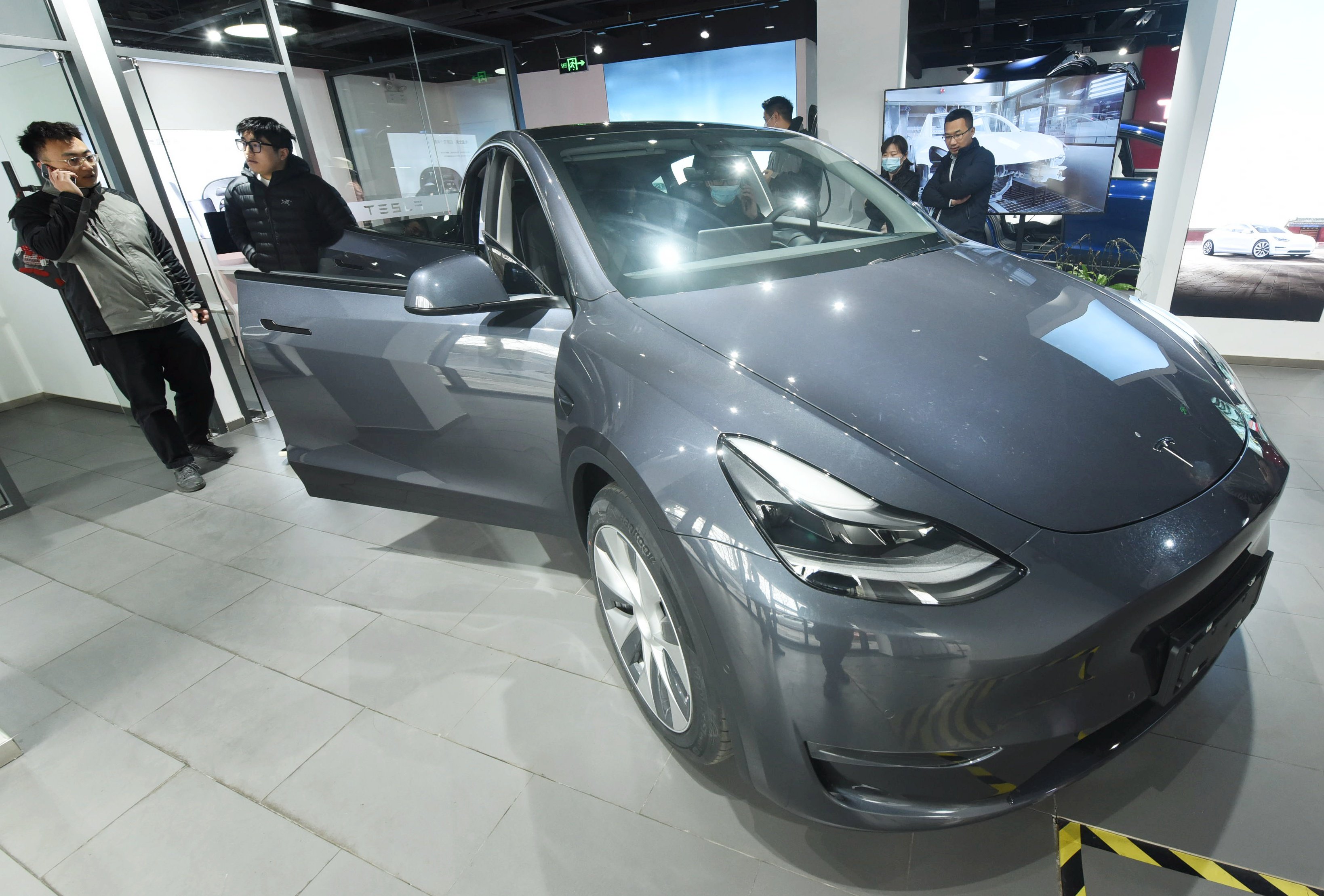 Customers look at the first Model Y electric cars arriving at a Tesla showroom in Hangzhou, east China’s Zhejiang province, on January 4, 2021. Photo: Costfoto/Barcroft Media via Getty Images