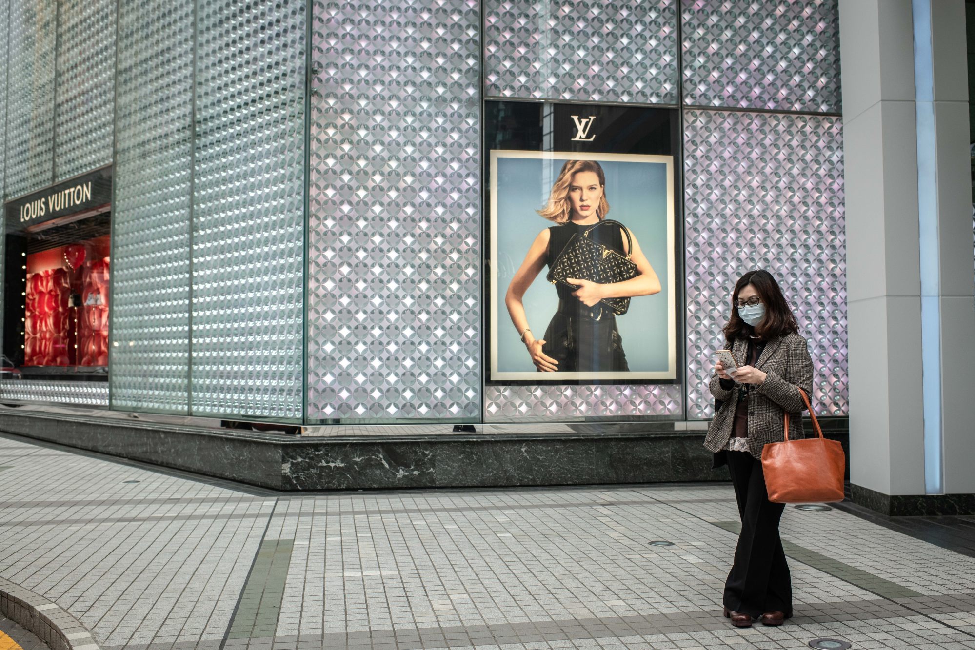 FILE--A pedestrian walks past a Louis Vuitton (LV) boutique of