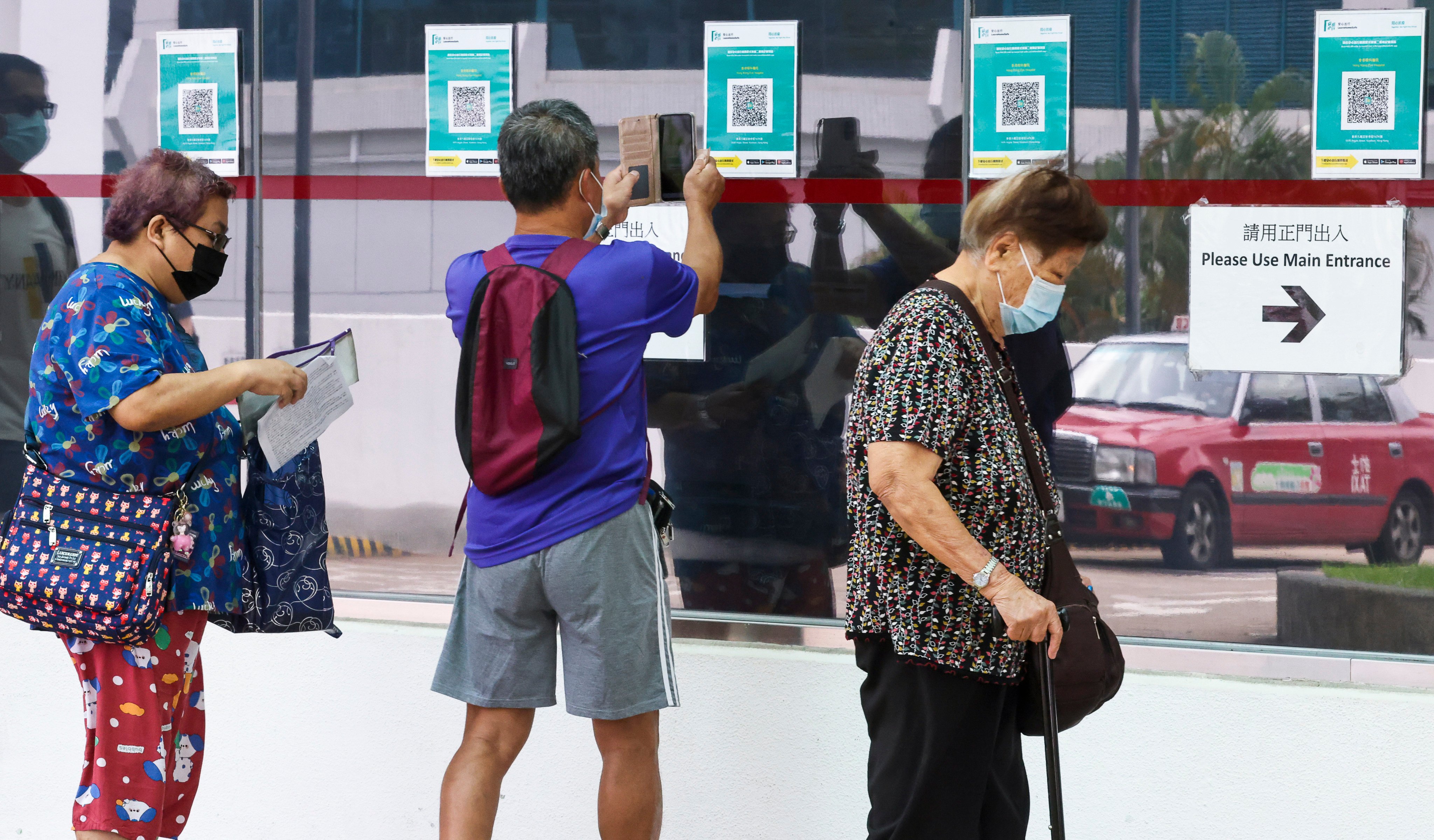 A man scans the QR code for the Covid-19 vaccine arrangements, at the Hong Kong Eye Hospital in Kowloon City, on June 13, 2022. Photo: K. Y. Cheng