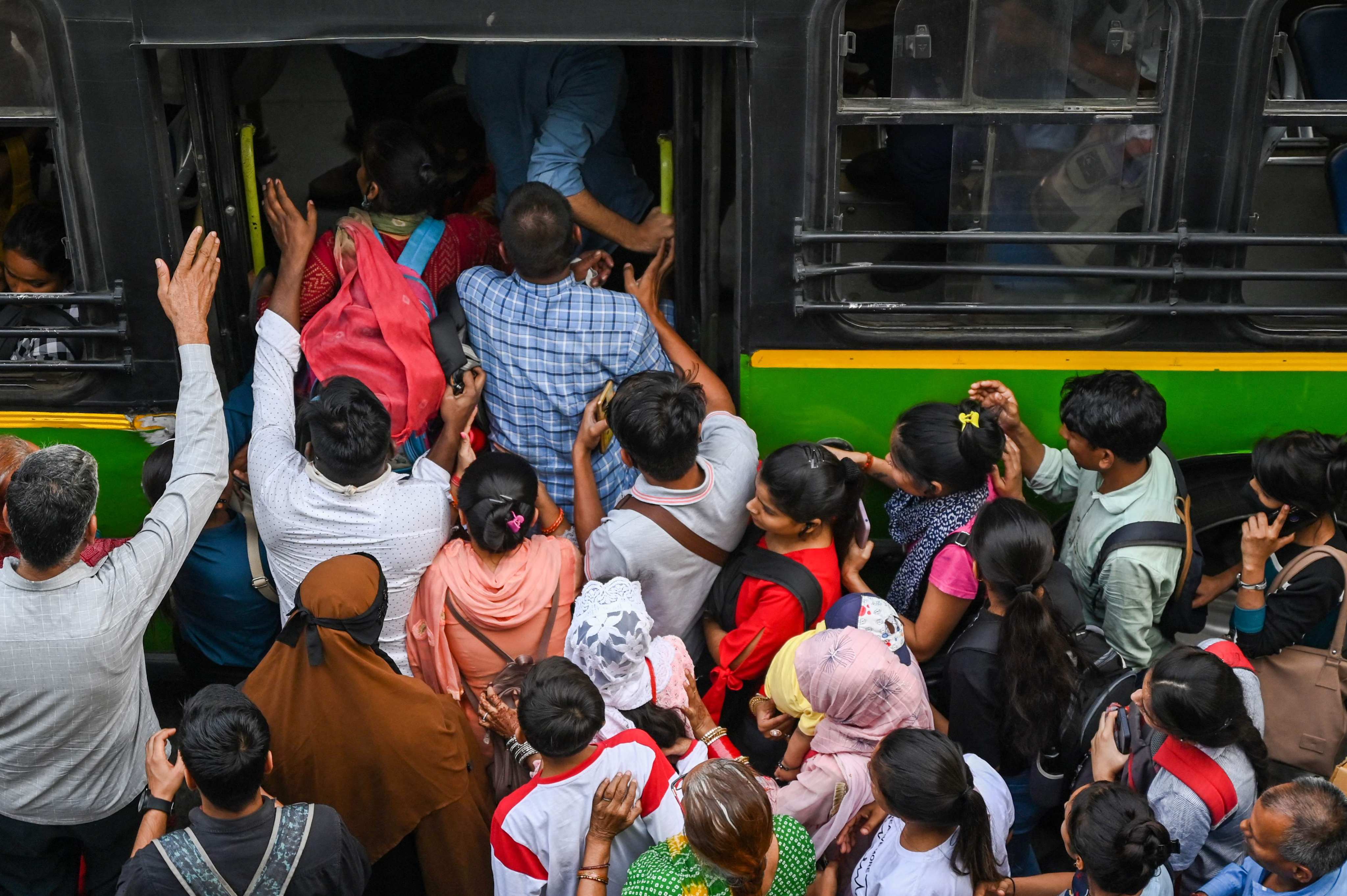 Commuters board an overcrowded bus at a bus stop in New Delhi. India is expected to overtake China as the world’s most populous country, but it faces several challenges before it can get the full benefit of its demographic dividend. Photo: AFP