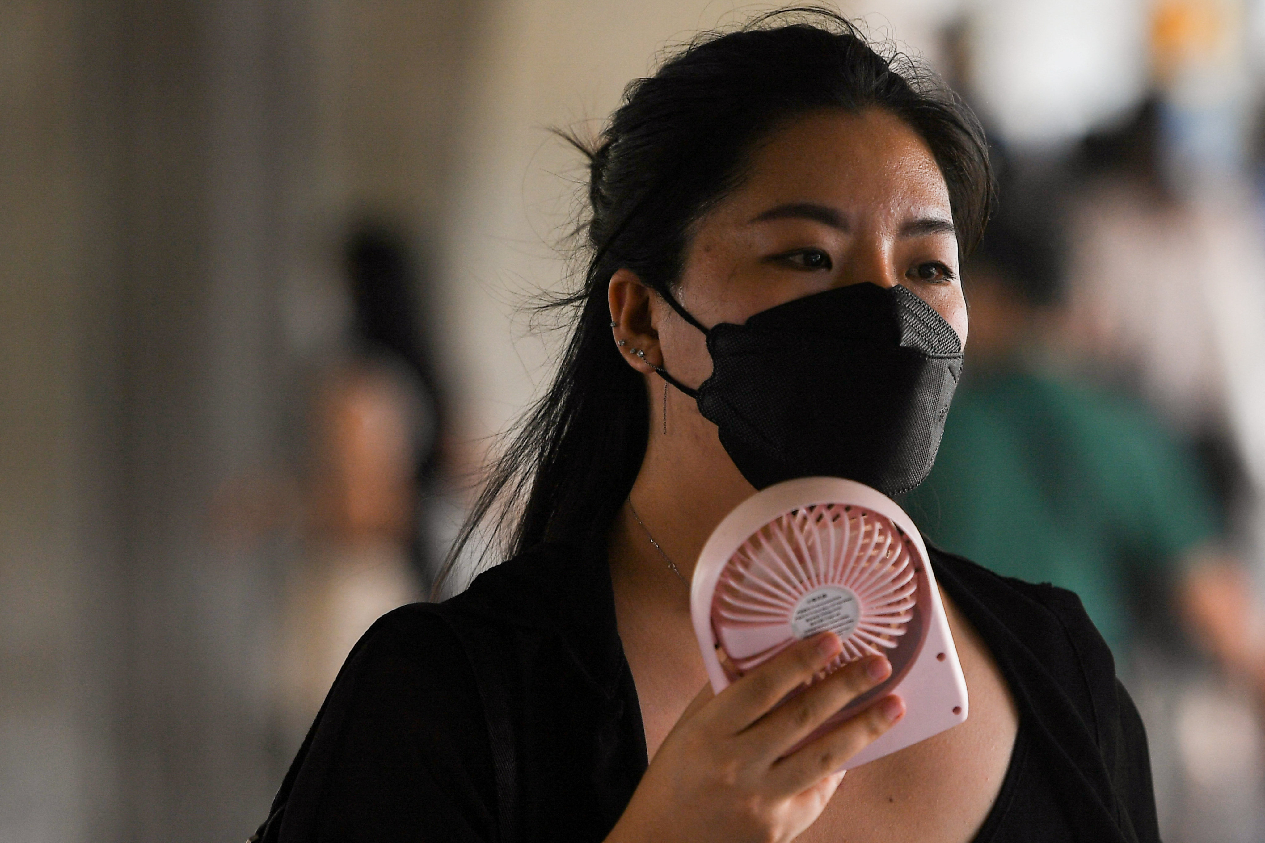 A woman uses a hand fan as temperatures hit a record 45.4 degrees Celsius (113.7 Fahrenheit) in Bangkok, Thailand, April 22, 2023. REUTERS/Chalinee Thirasupa