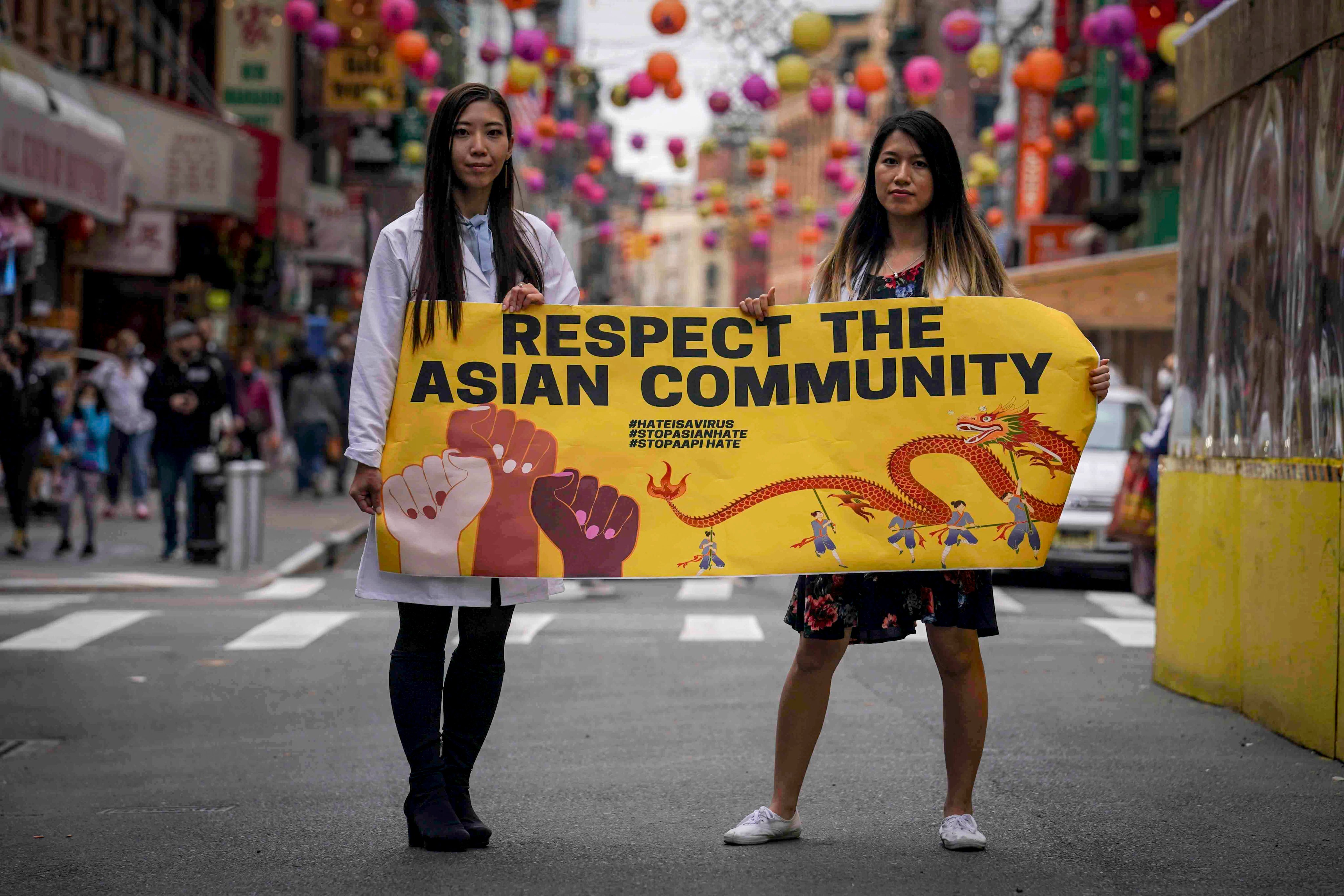 Michelle Lee (left) and Ida Chen hold a banner in New York’s Chinatown to protest anti-Asian hate in April 2021. Photo: AP