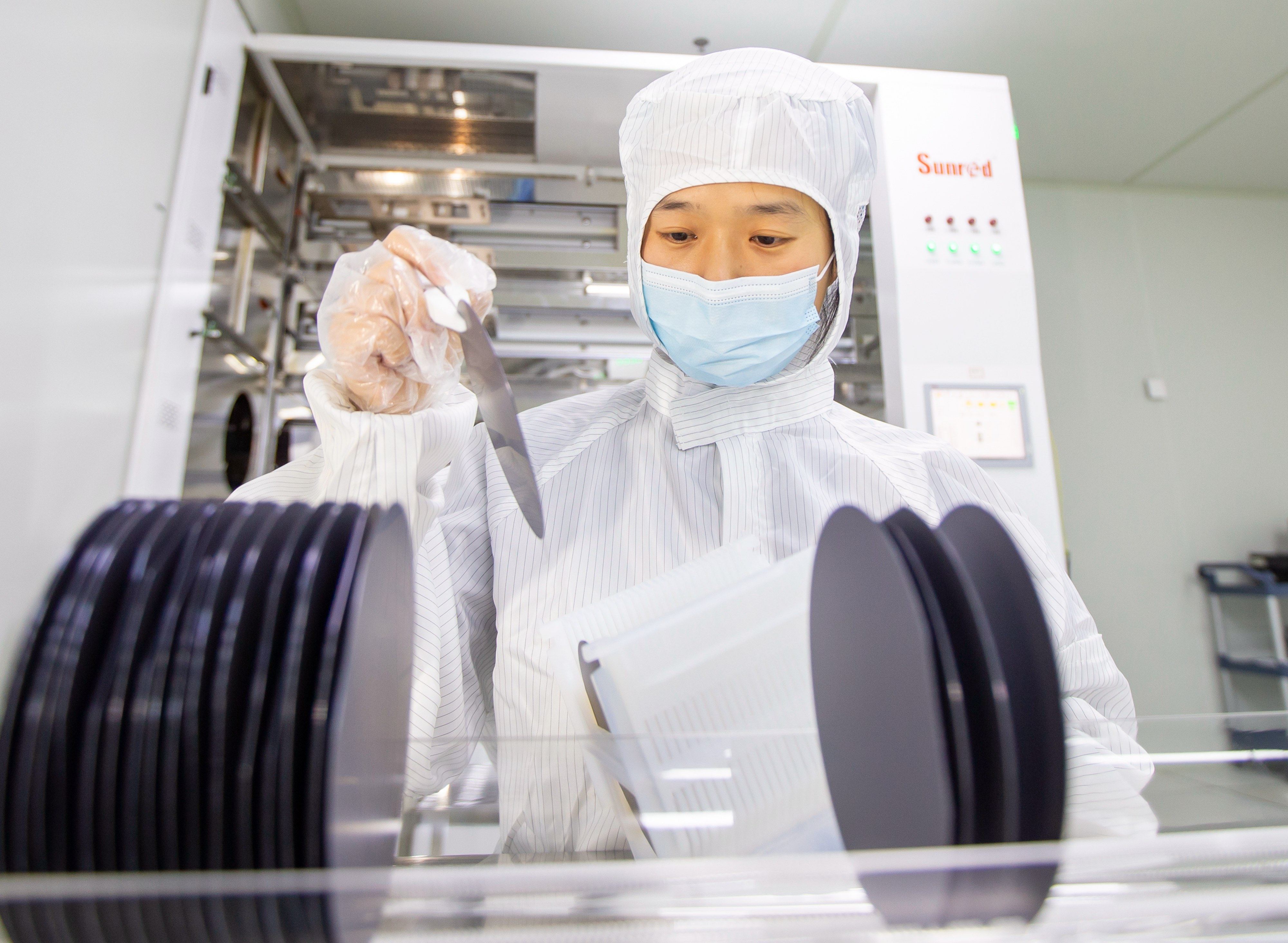 A workers holding semiconductor chips at a microelectronics enterprise in Hai’an, Jiangsu Province of China. Photo: VCG via Getty Images