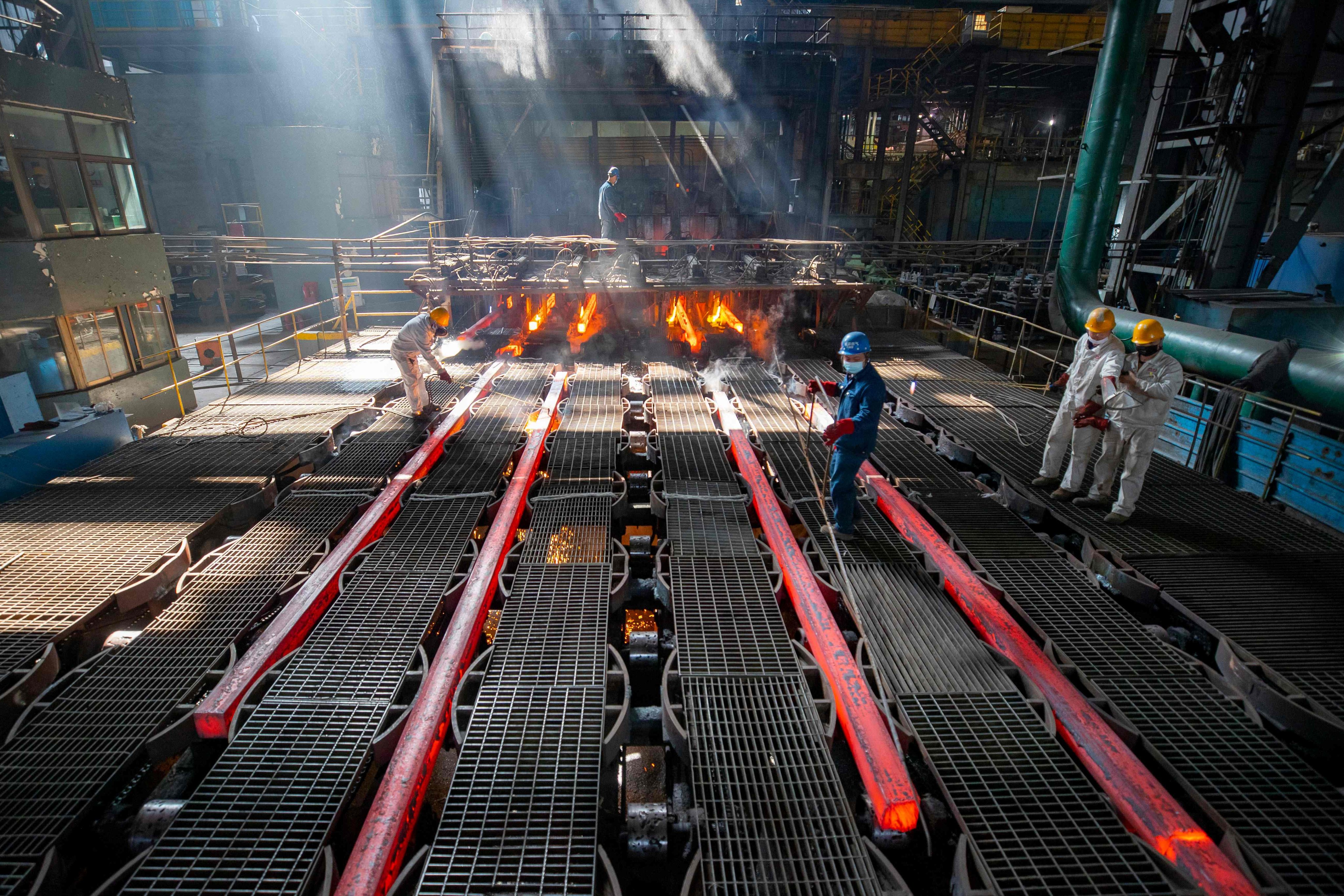 Workers make iron bars in a steel factory in Lianyungang, in China’s eastern Jiangsu province, on February 12, 2021. Photo: AFP