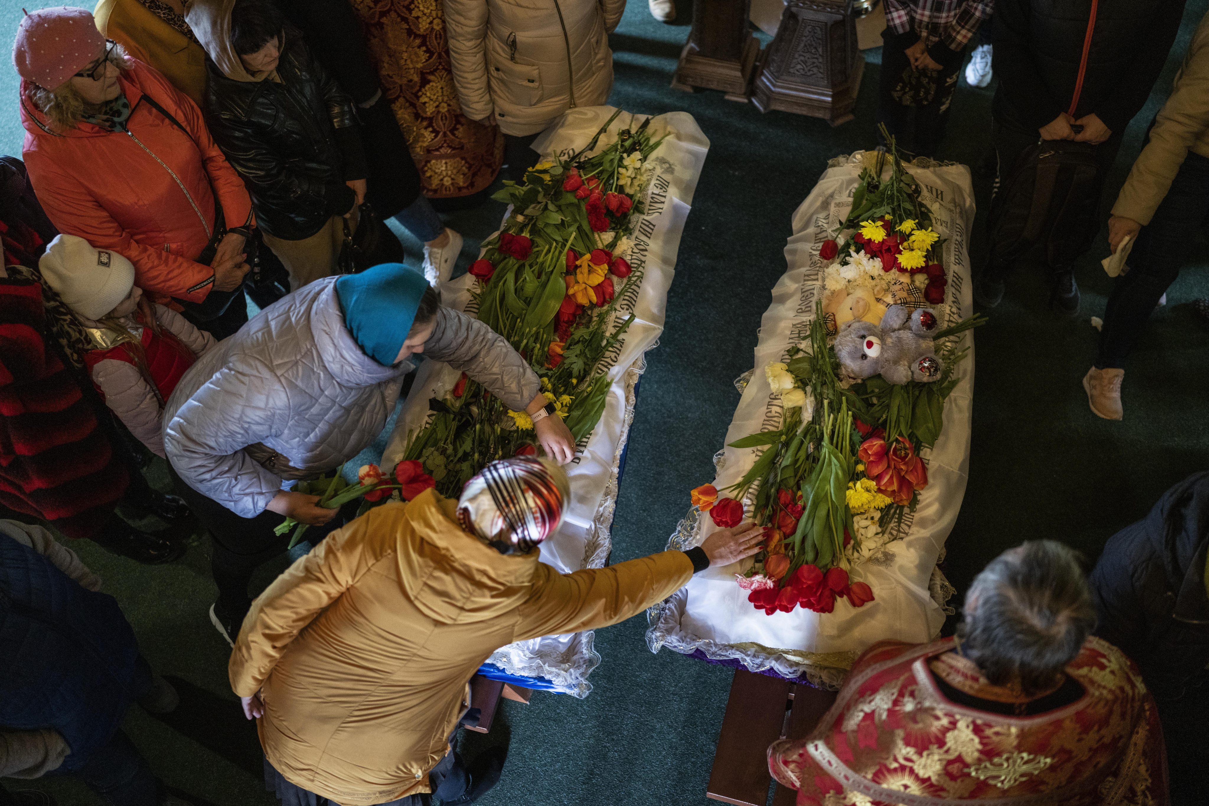 Mourners place flowers on the coffins of Sofia Shulha, 11, and Pysarev Kiriusha, 17, who were killed during a Russian attack. Photo: AP