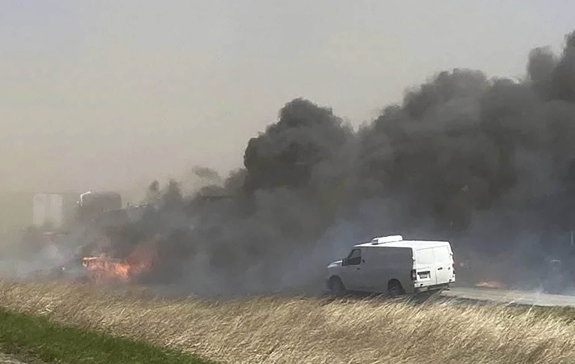 Smoke billows after crashes involving dozens of vehicles shut down a highway in Illinois on Monday. Photo: WICS TV via AP