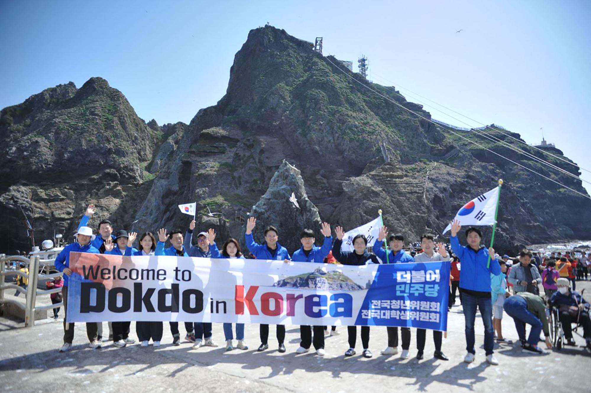 جنوبی کوریا کے سیاستدان جیون یونگ گی کے دفتر کا عملہ متنازع جزیروں پر ایک تصویر لے رہا ہے۔ فوٹو: اے ایف پی