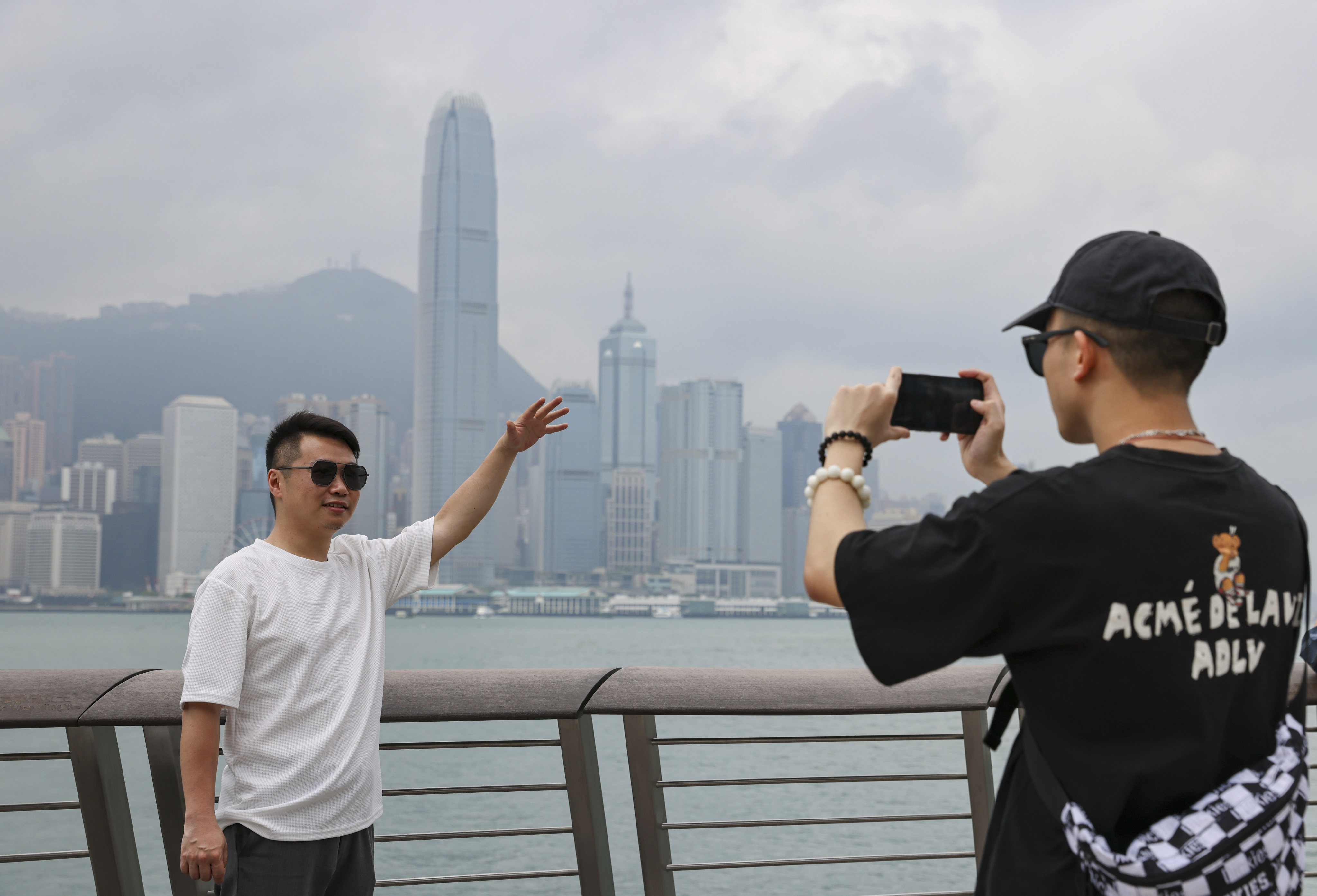 Mainland tourists Zeng Hui (left) and Chen Jiayi follow a trend on Xiaohongshu of recreating a well-known photo of Hong Kong billionaire Li Ka-shing. Photo: May Tse