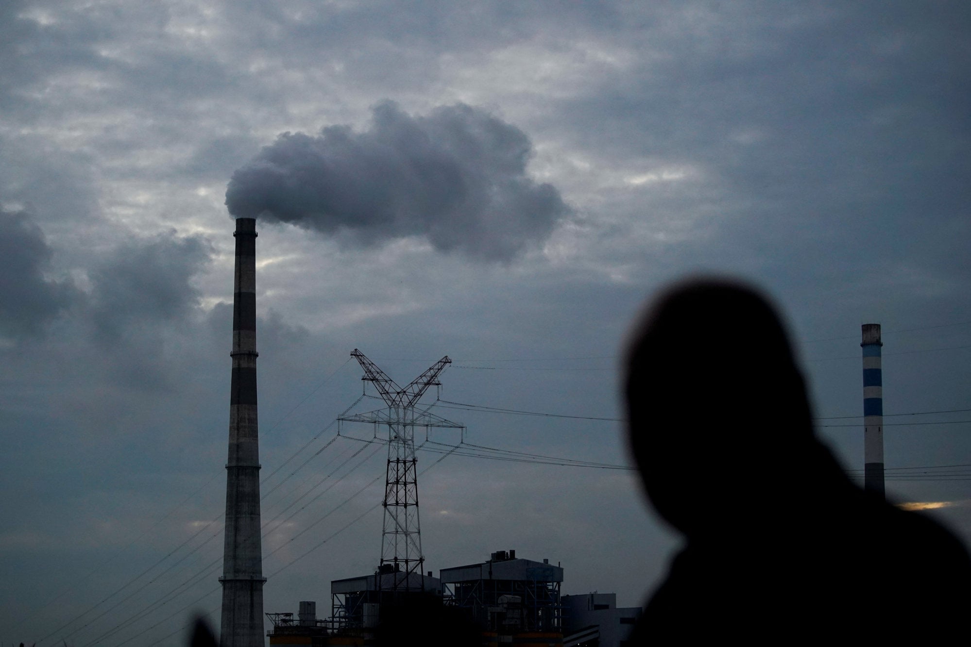 A man walks past a coal-fired power plant in Shanghai, China. Photo: Reuters A man walks past a coal-fired power plant in Shanghai, China. Photo: Reuters