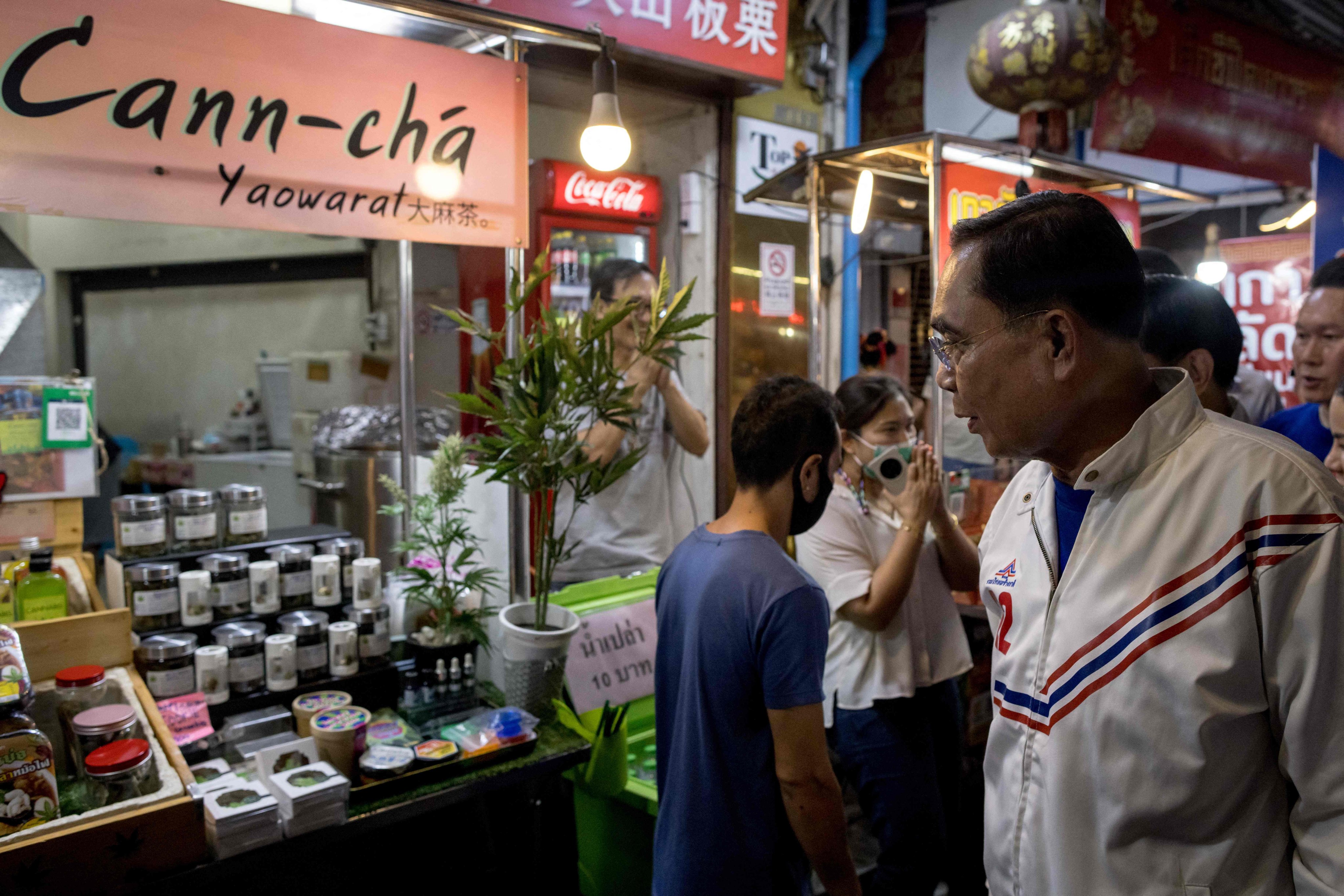 Thai Prime Minister and United Thai Nation Party candidate Prayuth Chan-ocha looks at a stall selling cannabis as he campaigns in the Chinatown area of Bangkok on April 20, 2023. Photo: AFP
