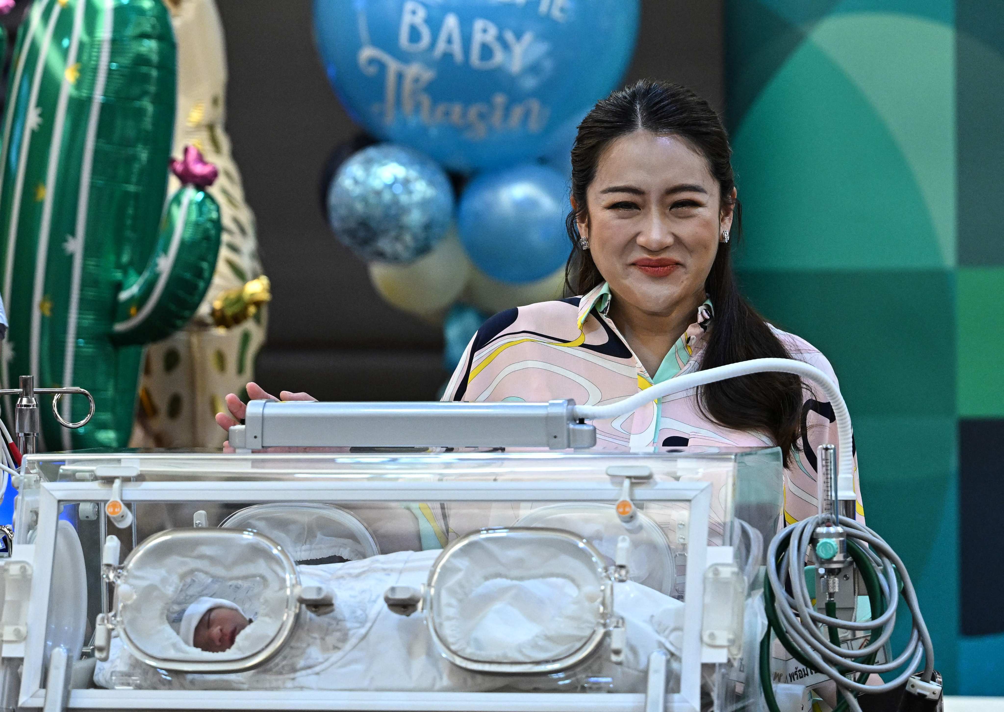 Paetongtarn Shinawatra presents her newborn son Thasin in an incubator while addressing media. Photo: AFP