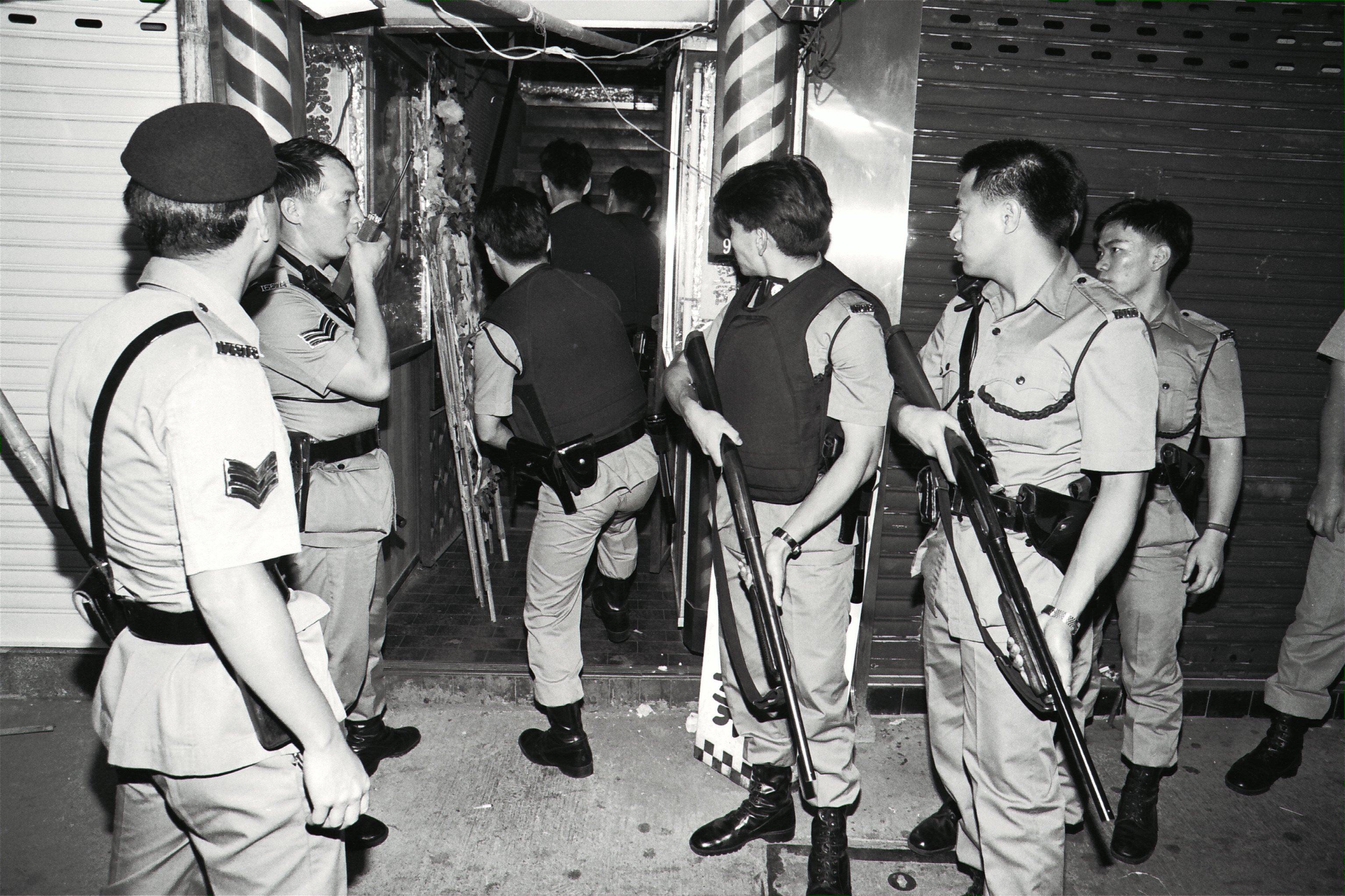 Armed police search a building after a gang firing guns and lobbing grenades in a robbery at a mahjong parlour in Mong Kok, Hong Kong, in 1992, killed two men, injured 19 other people and stole HK$2 million. Photo: SCMP